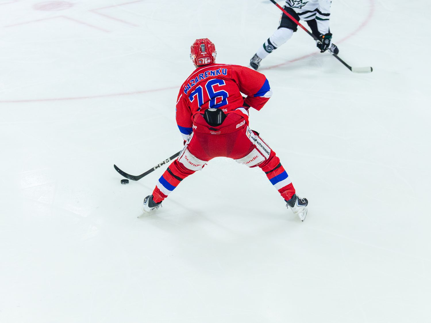 Hockey players in red and white jerseys competing for the puck on ice.