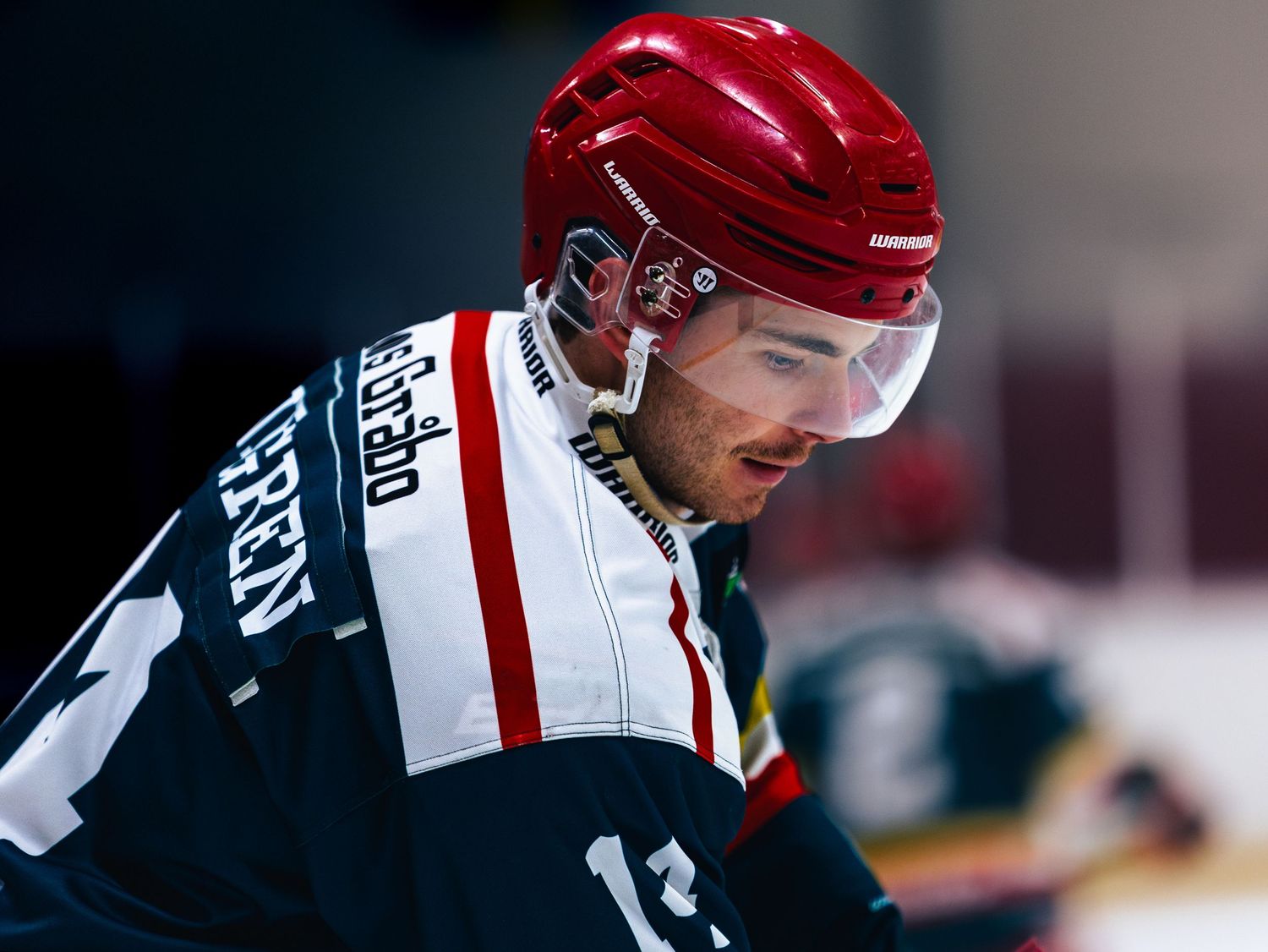 Close-up of hockey players in red and black jerseys during a game.