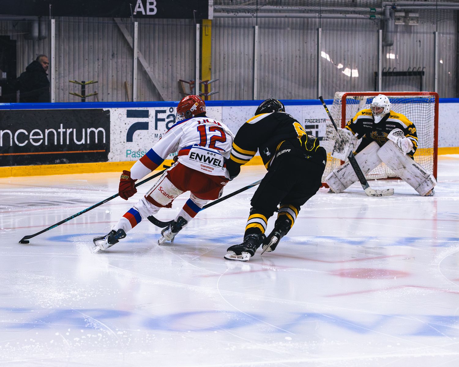 Hockey goalie makes a diving save attempt on the ice during an intense game moment.