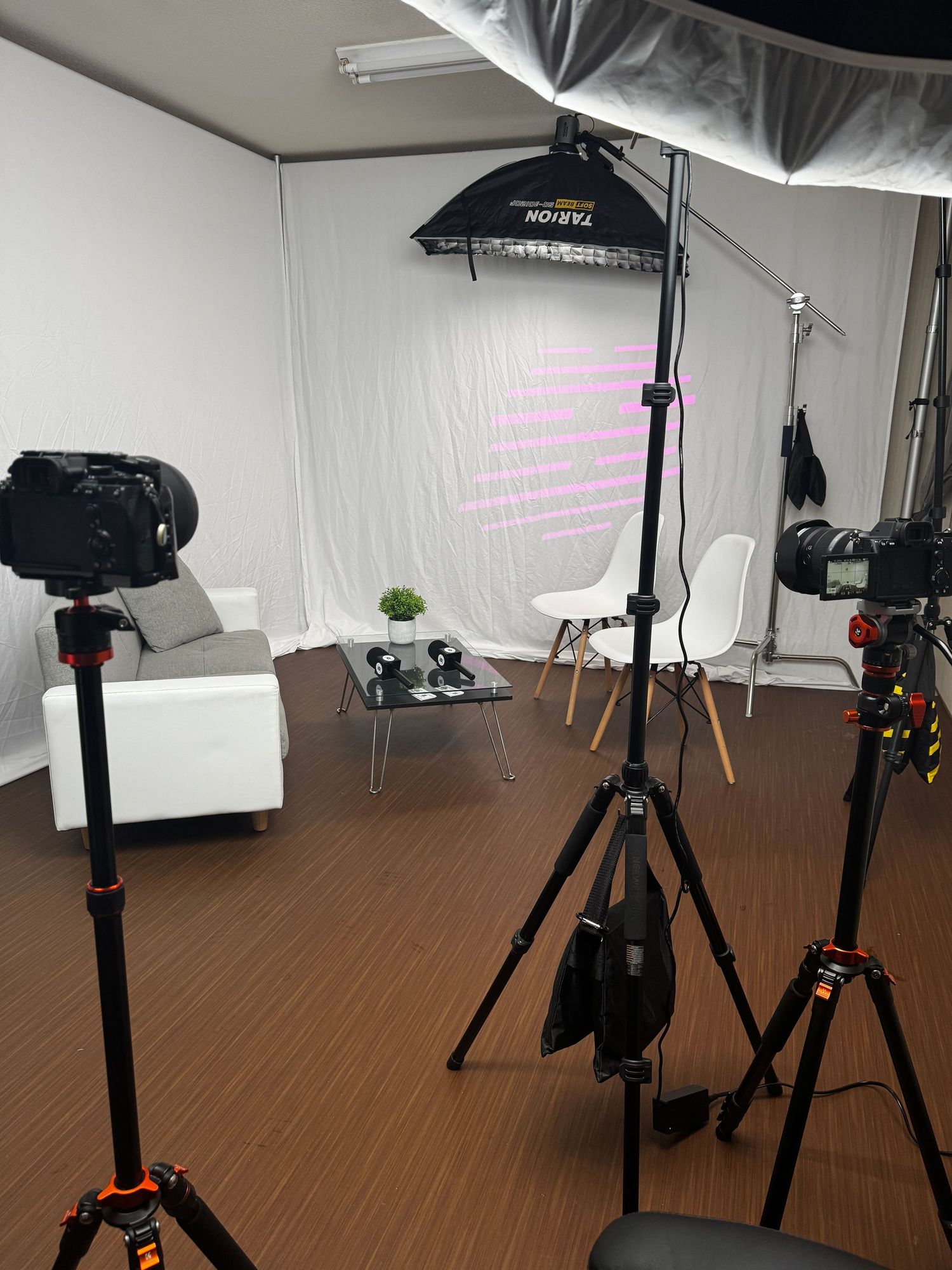 Photography studio setup showing lighting equipment, tripods, and softboxes arranged in a professional workspace.