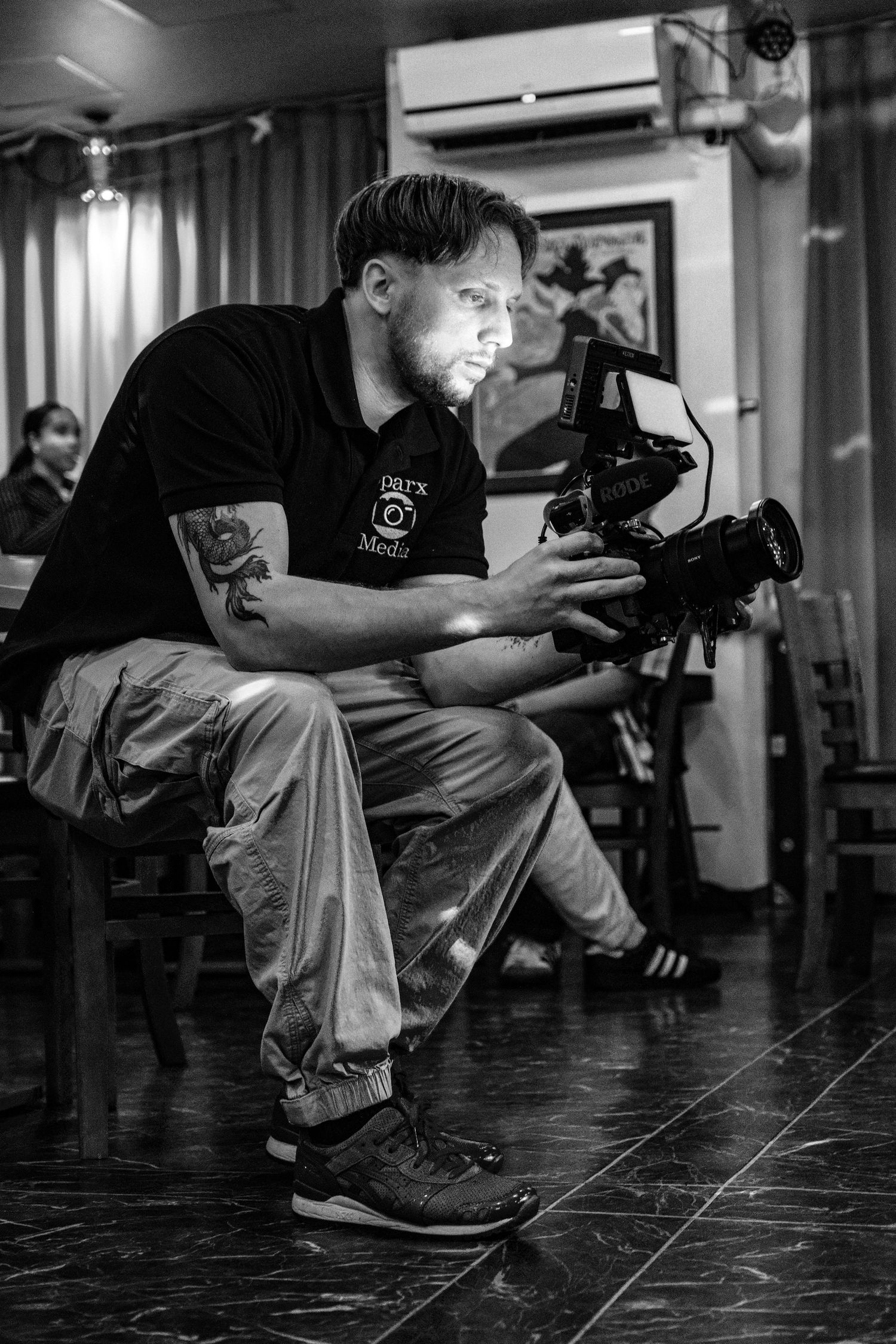 Black and white photo of photographers crouching to get low-angle shots.