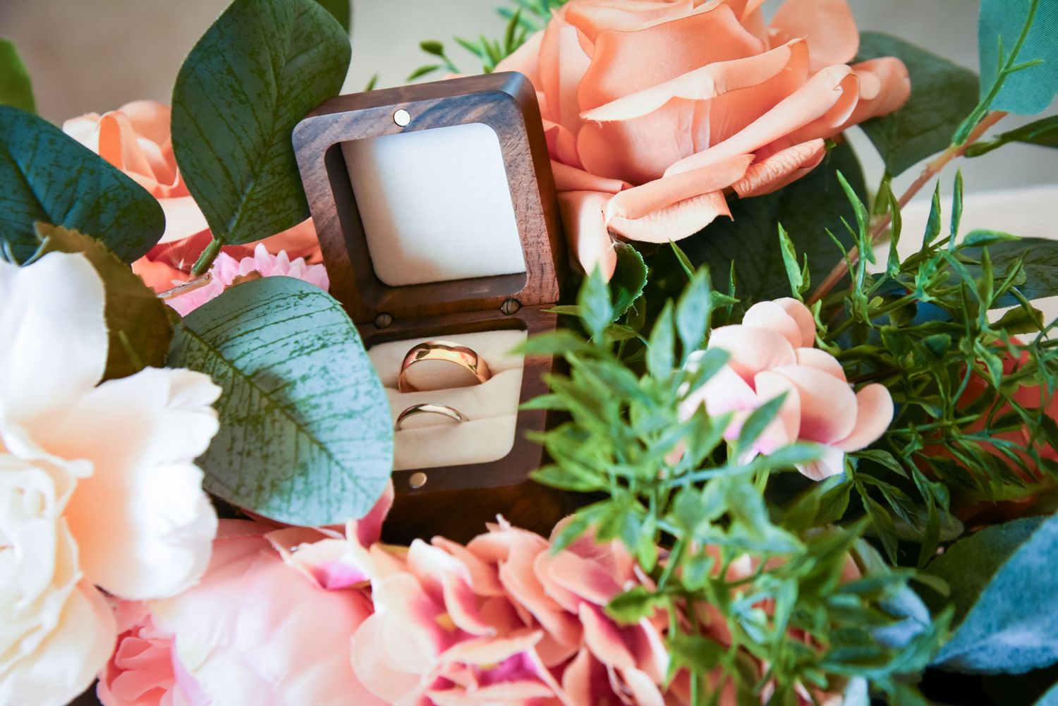 Pink roses and baby's breath flowers arranged in a decorative floral border with green leaves.
