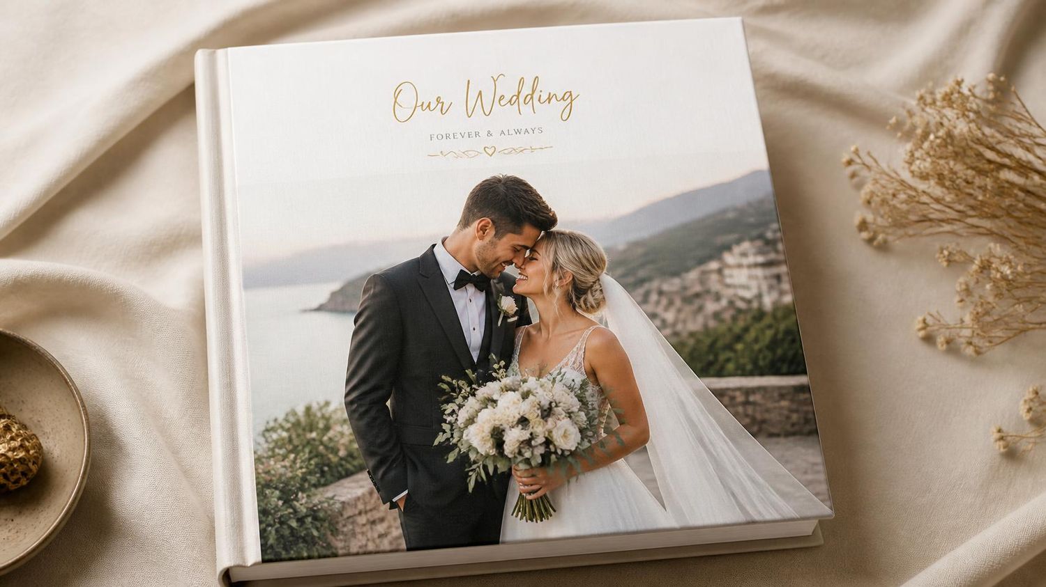 Elegant wedding photo book with a couple embracing, titled Our Wedding, set against a scenic coastal backdrop.