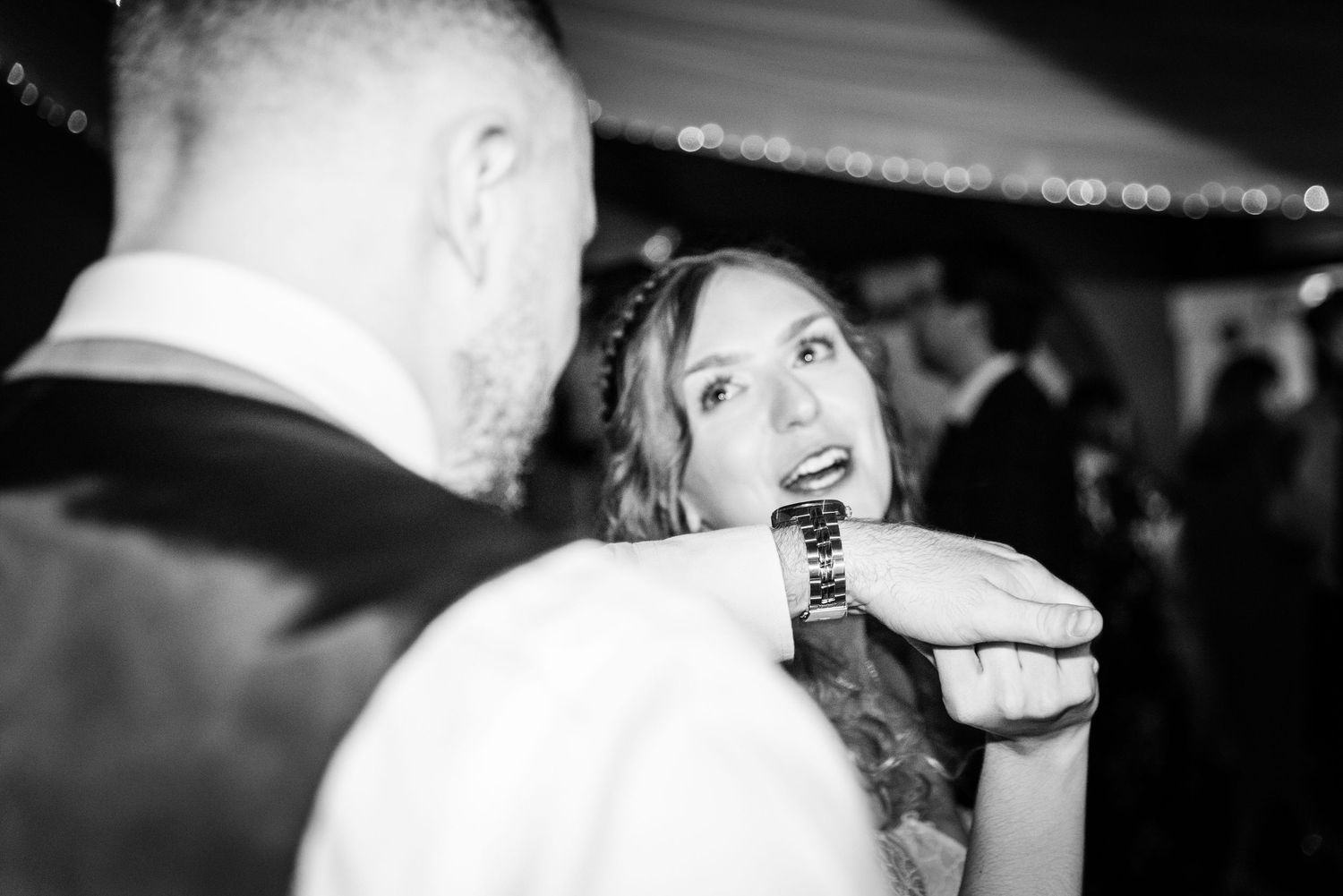 Black and white photo of bride and groom sharing intimate dance moment.