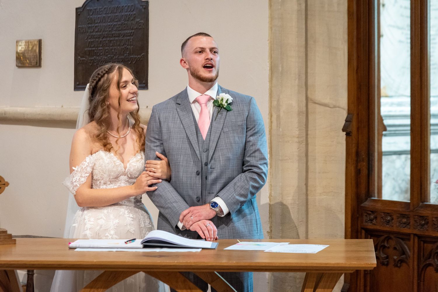 Bride and groom laughing together at the altar during their wedding ceremony signing.