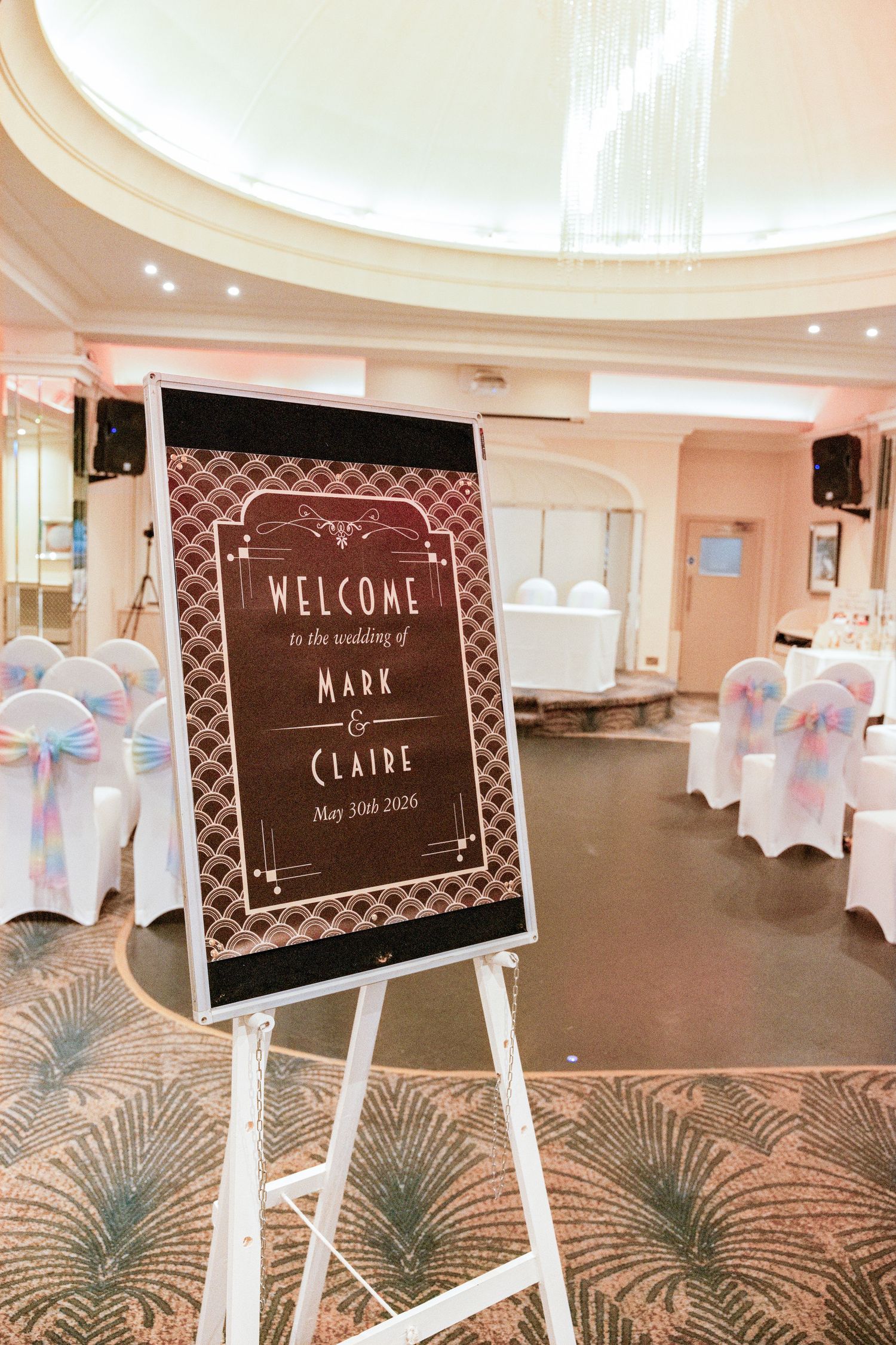 Elegant wedding welcome sign for Mark and Claire on May 30th 2020, displayed on a white easel in a decorated reception hall.