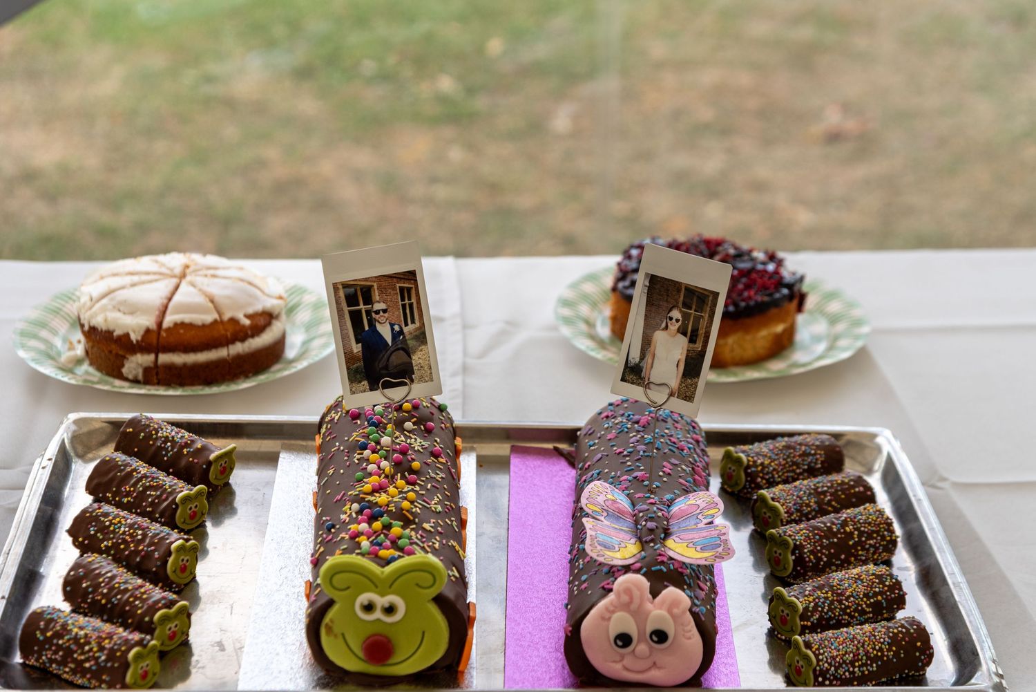 Wedding dessert table featuring decorated yule log cakes and vintage photo displays.