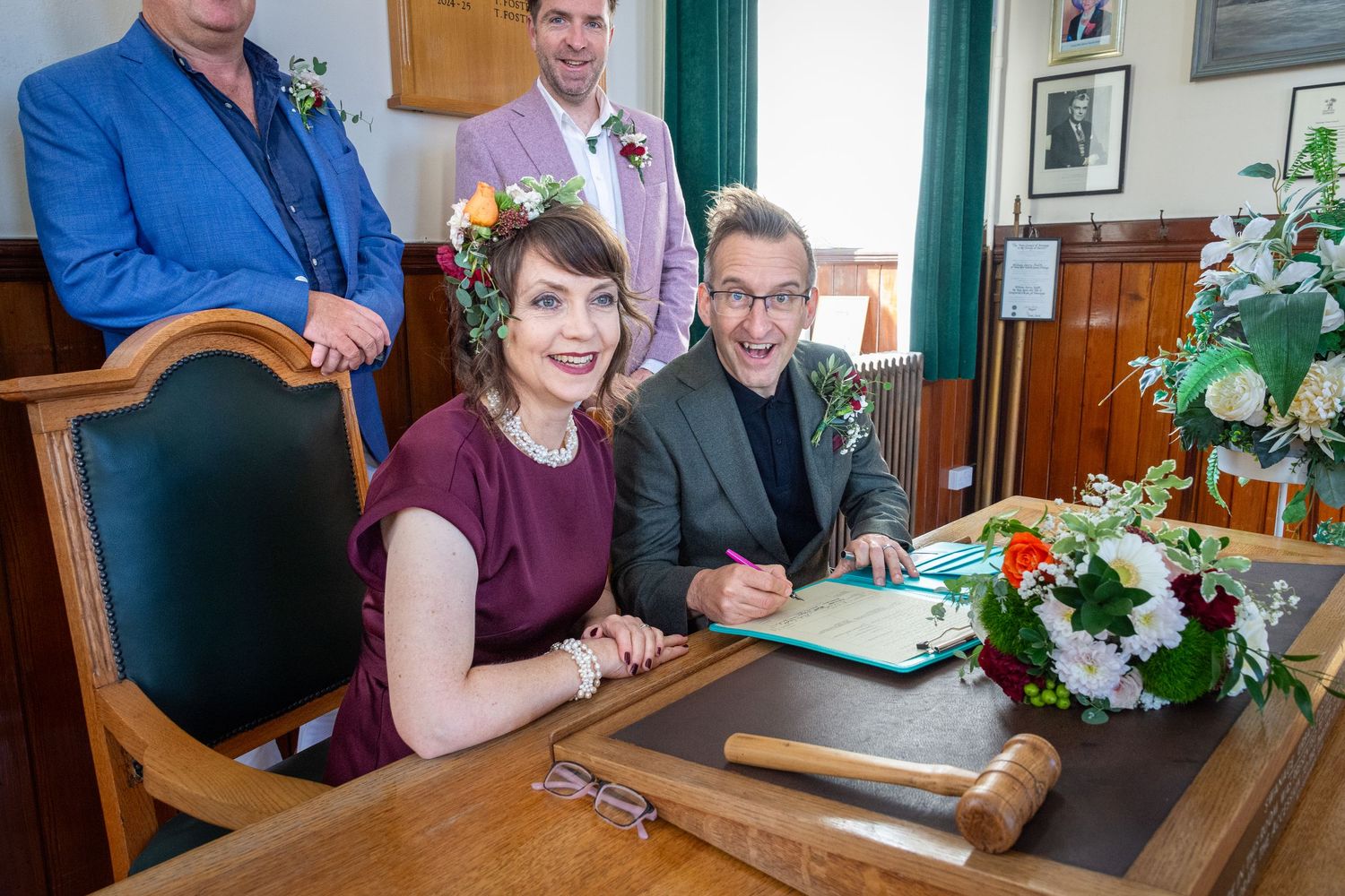 People gathered around a table at a restaurant signing documents and papers during a business meeting.