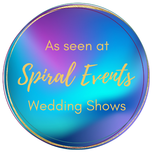 A circular metallic badge with holographic colors displaying 'As seen at Spiral Events Wedding Shows' in gold text.