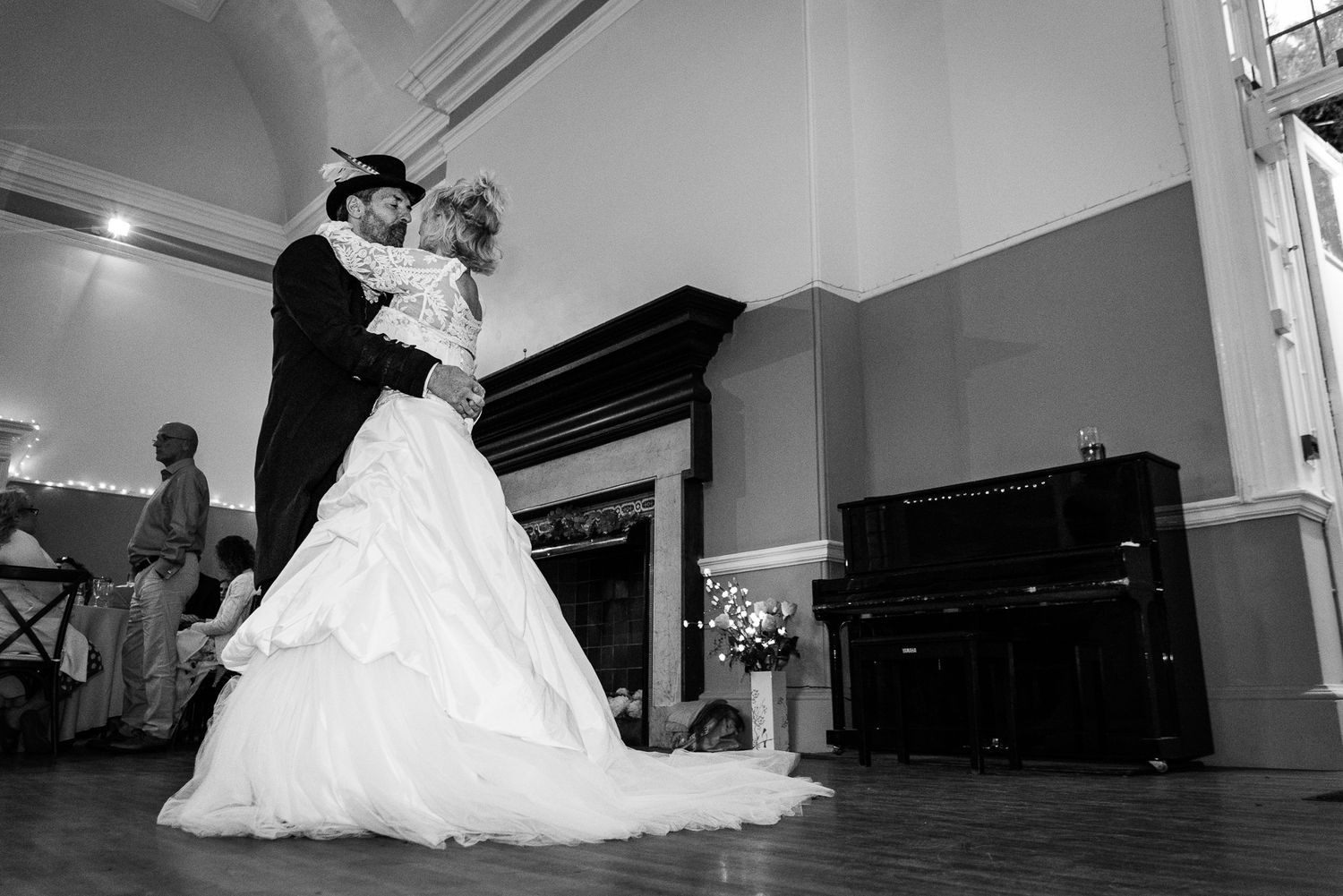 Black and white photo of a bride and groom sharing their first dance at an elegant wedding reception.
