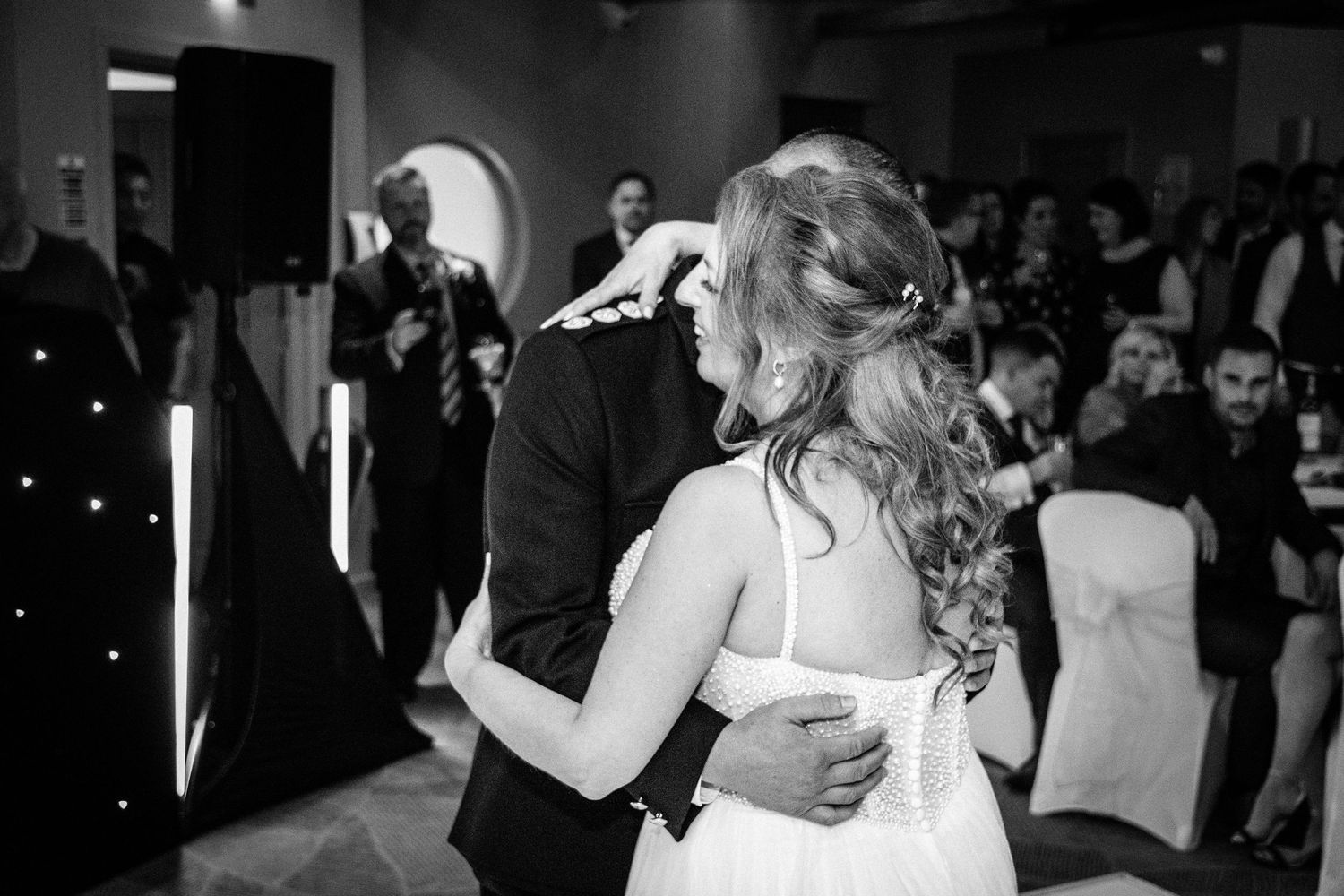 Bride and groom share their first dance in black and white wedding reception photo.