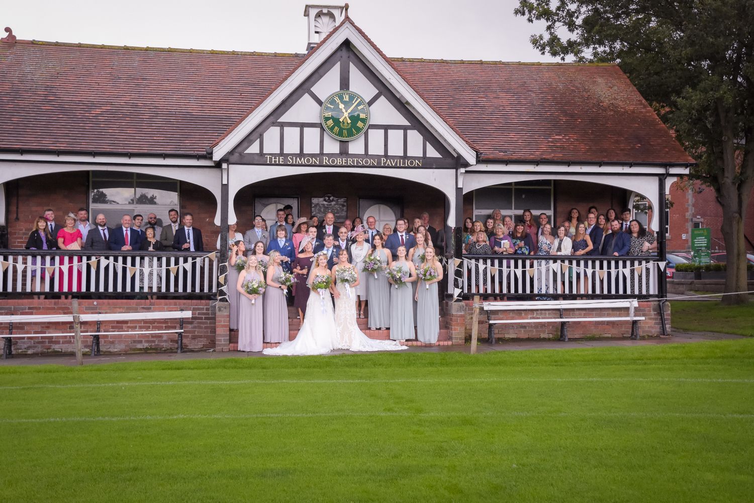 A series of five connected photos showing a wedding ceremony and celebration at a rustic white barn venue with red trim.
