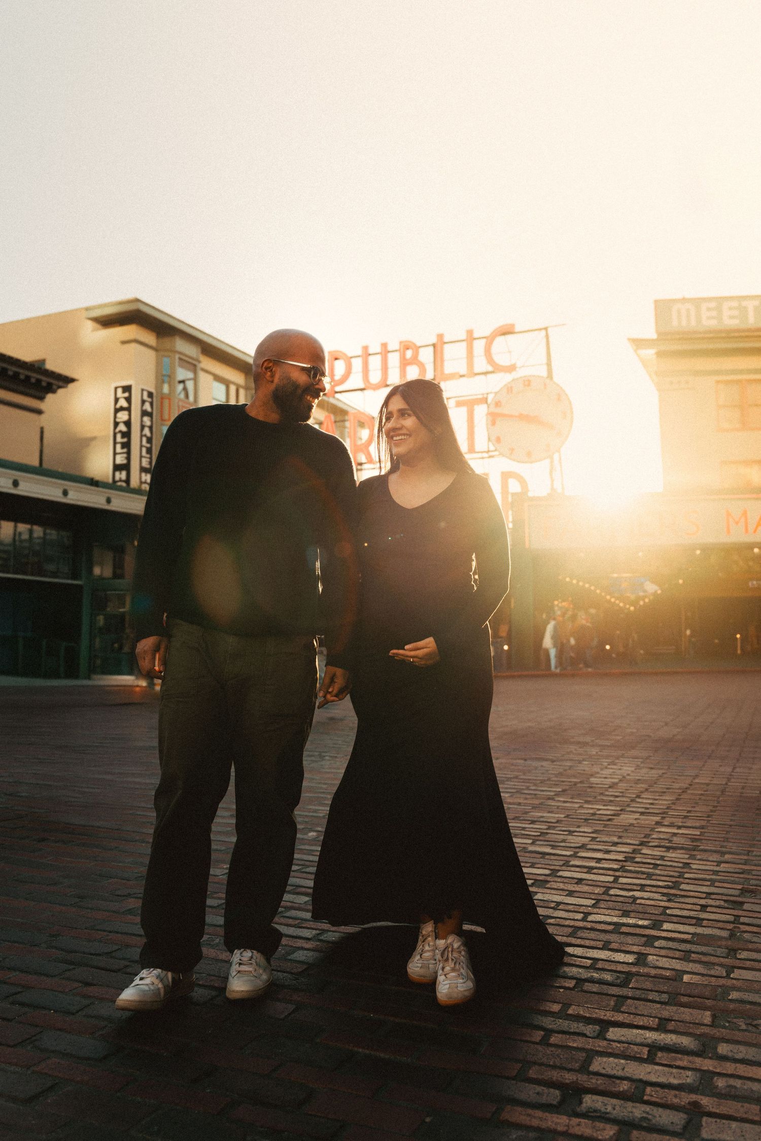 A couple walks together at sunset near Pike Place Market in Seattle, Washington.