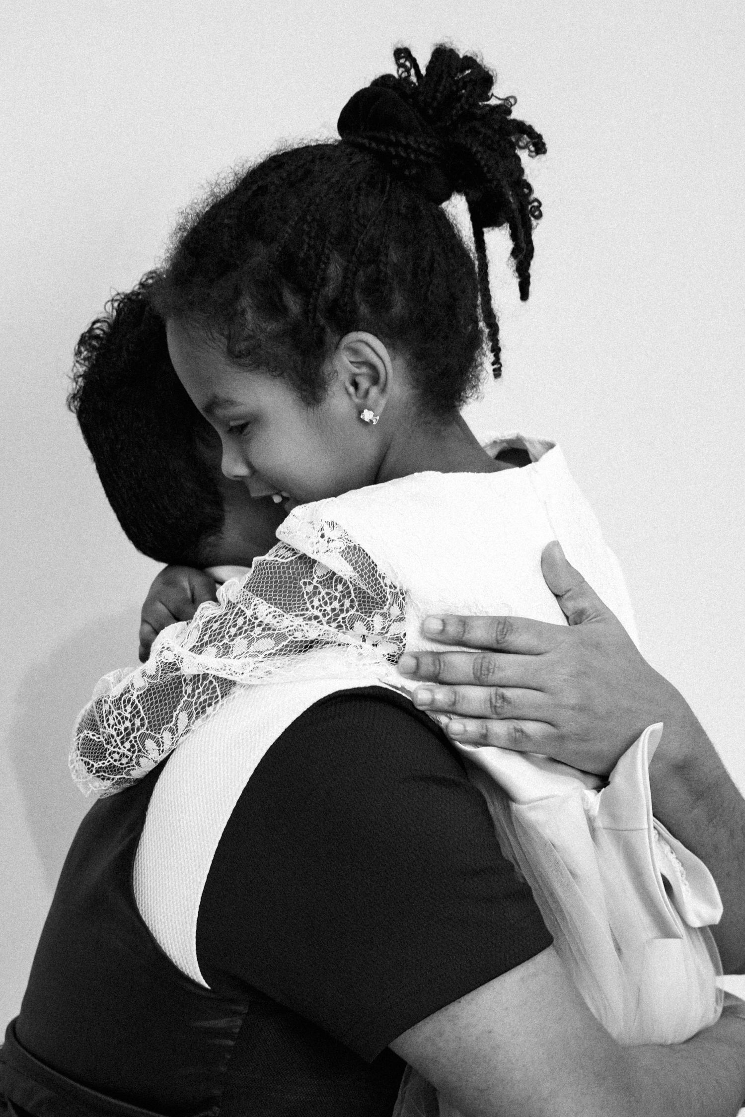 Black and white photo of two women sharing a warm embrace, one resting her head on the other's shoulder.