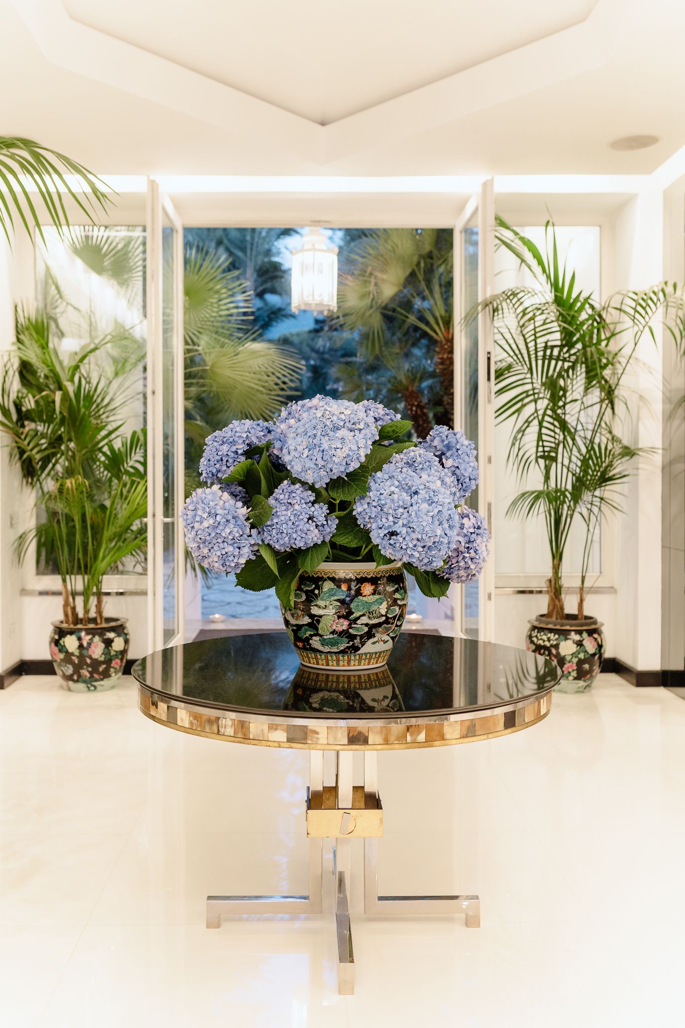 Blue hydrangeas in decorative vase on gold table in elegant hotel lobby in Villa Silvana.