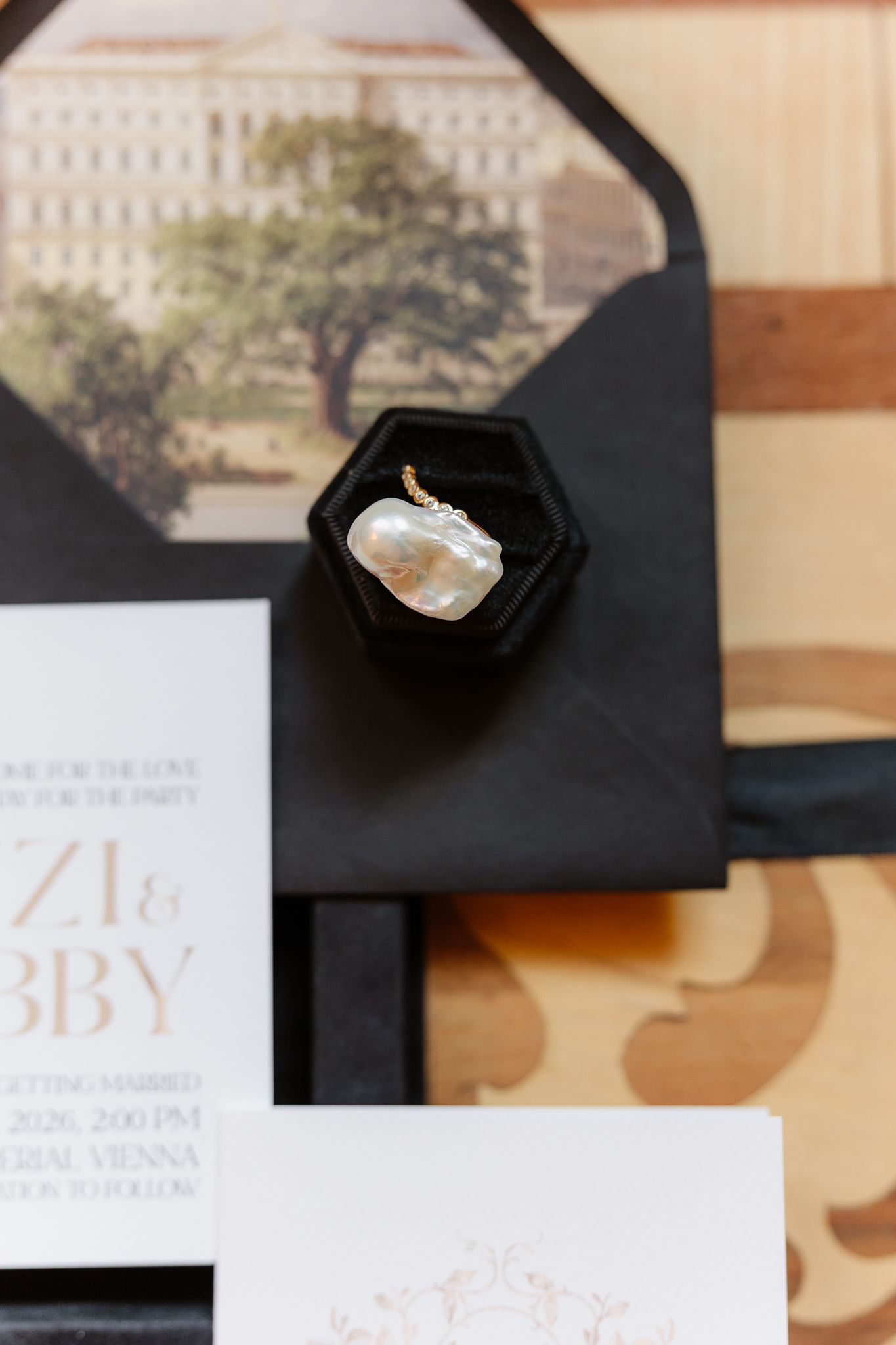 Baroque pearl ring in black velvet hexagon box on wedding invitation suite with envelope liner.