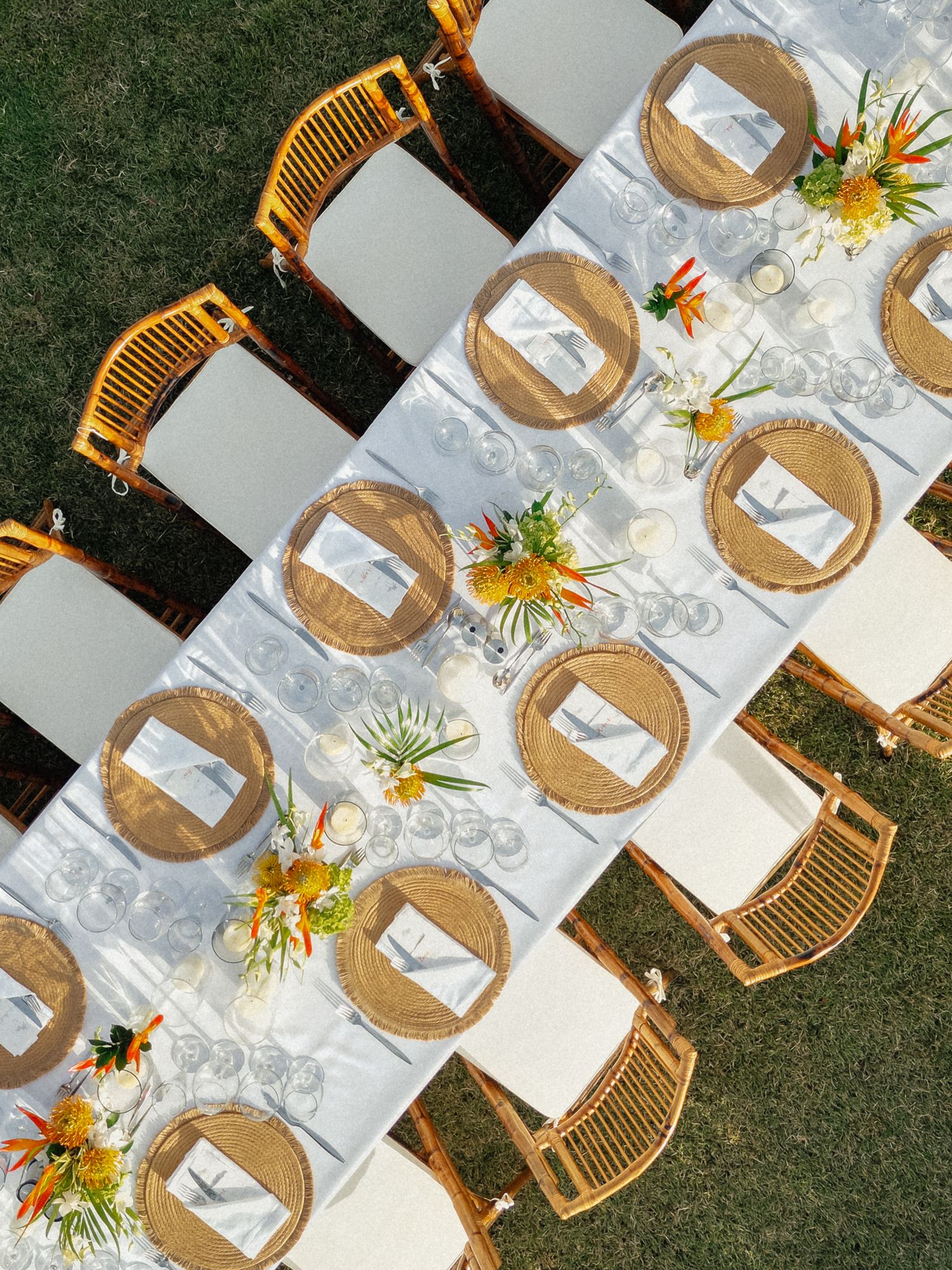 Aerial view of wedding tablescape with woven chargers, and tropical floral centerpieces. Barbados Destination Wedding Photographer
