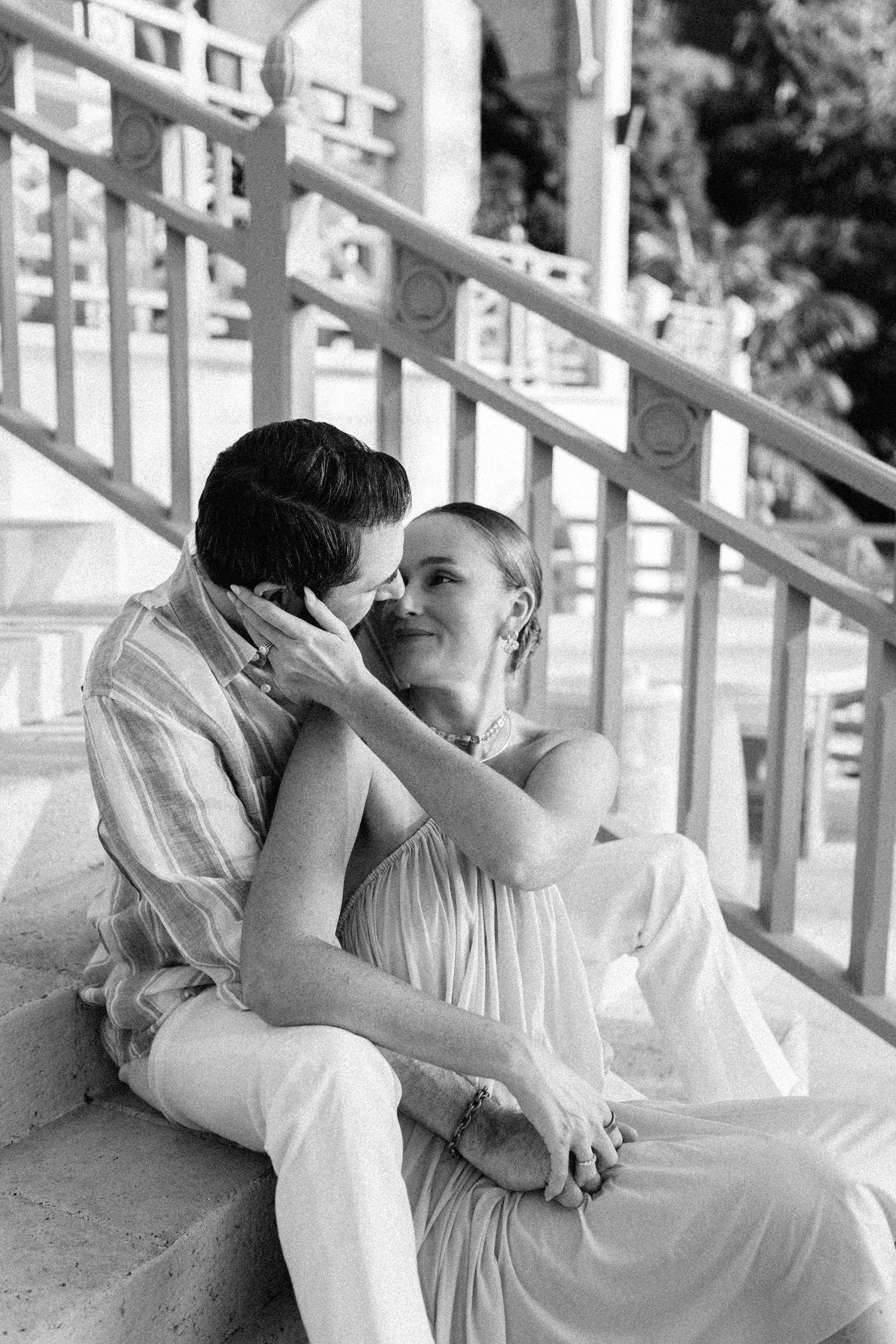 Black and white photo of couple sharing intimate moment seated on outdoor staircase steps. Barbados Destination Wedding Photographer