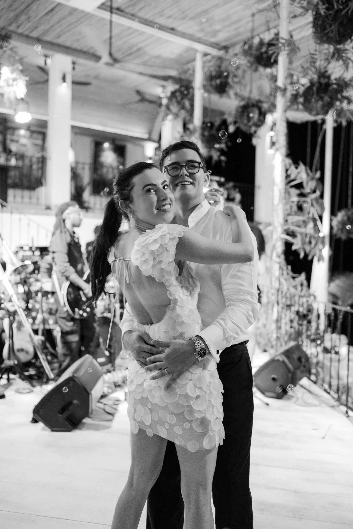 Bride and groom share a joyful first dance embrace at their elegant wedding reception in black and white. QP Bistro, Barbados
