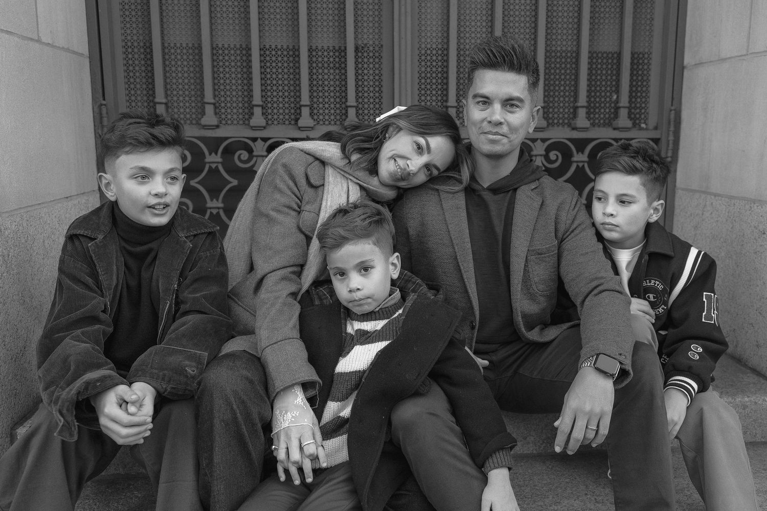Black and white portrait of a family of five sitting together on outdoor steps.  | Karina Thomson Photography Raleigh NC