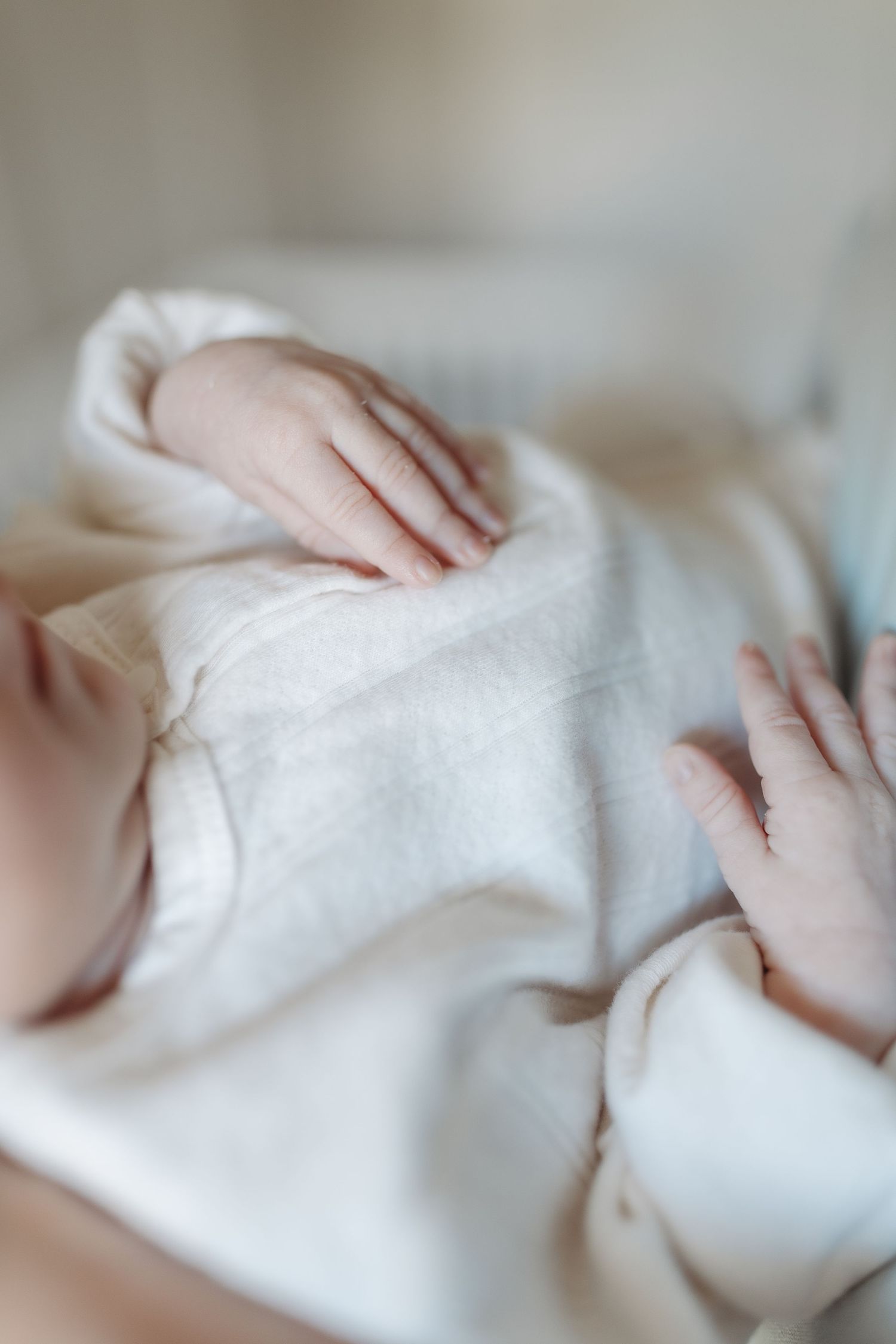 Close-up of a sleeping newborn baby swaddled in a soft white muslin blanket.  | Karina Thomson Photography Raleigh NC
