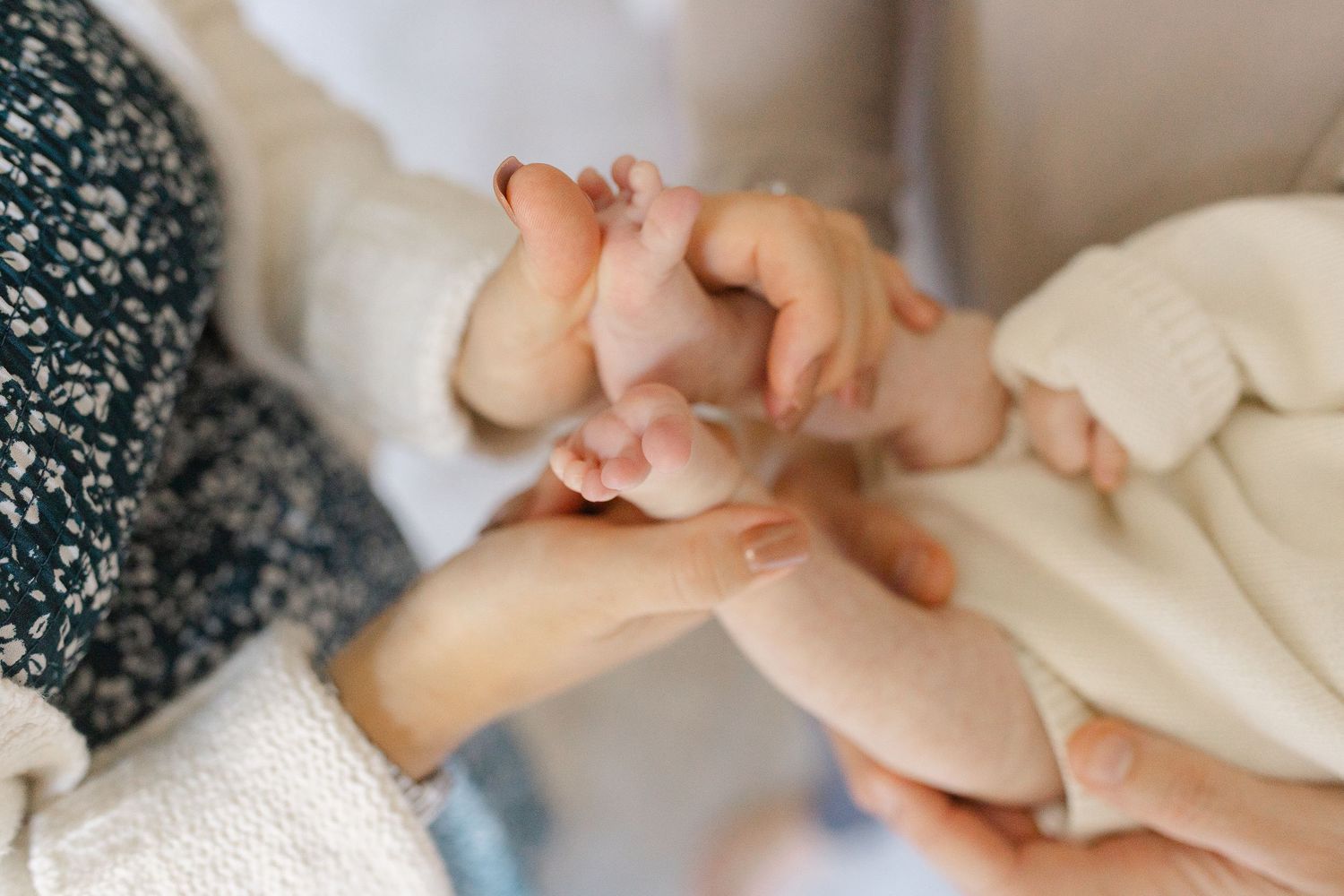 Close-up of parents gently holding their newborn baby hands and tiny feet together.  | Karina Thomson Photography Raleigh NC