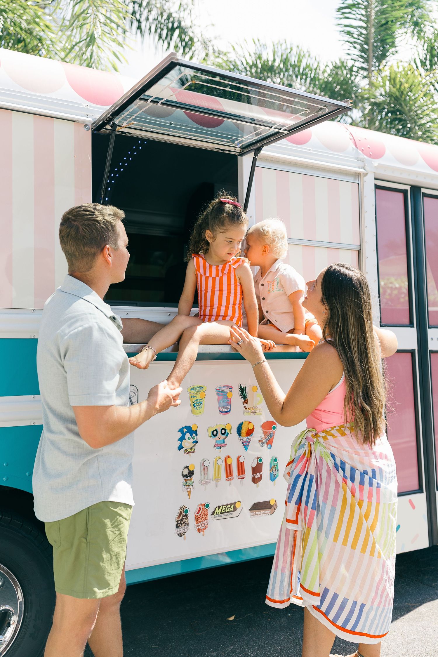 Family with two children enjoying ice cream truck on sunny day with tropical trees.  | Karina Thomson Photography Raleigh NC