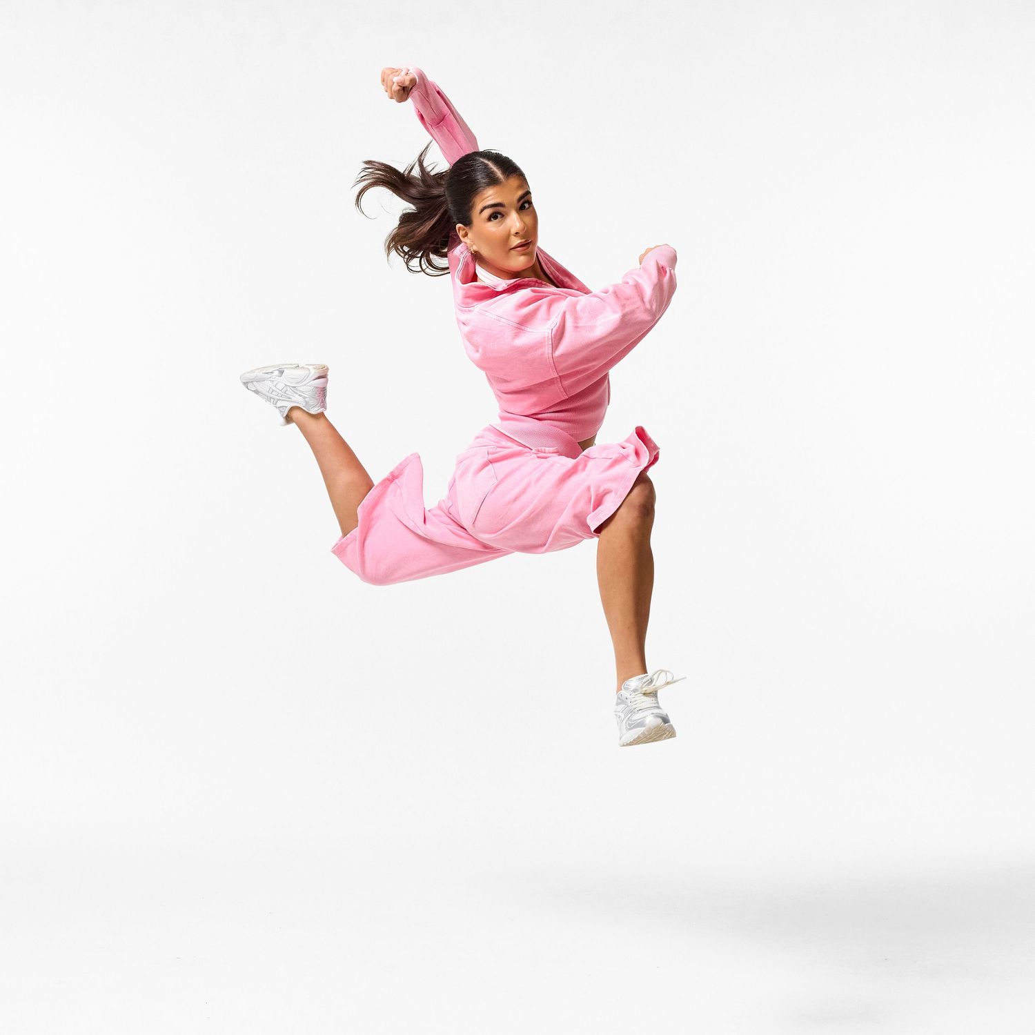 A modern dancer wearing stylish streetwear, captured in a dynamic, expressive pose against a clean white background.