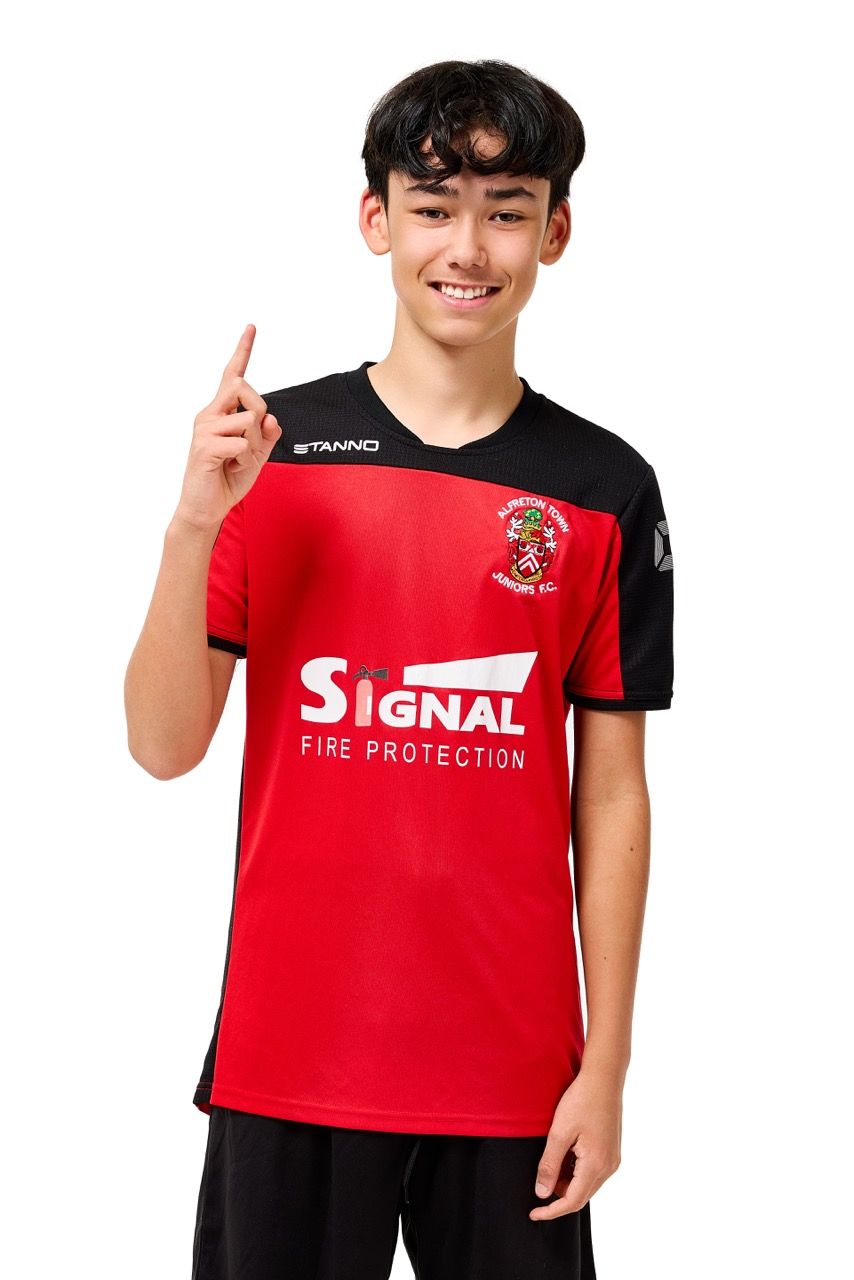 A young boy wearing a football kit, posing with a football against a clean white studio background.
