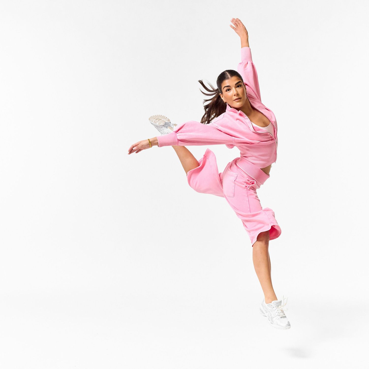 A modern dancer wearing stylish streetwear, captured in a dynamic, expressive pose against a clean white background.
