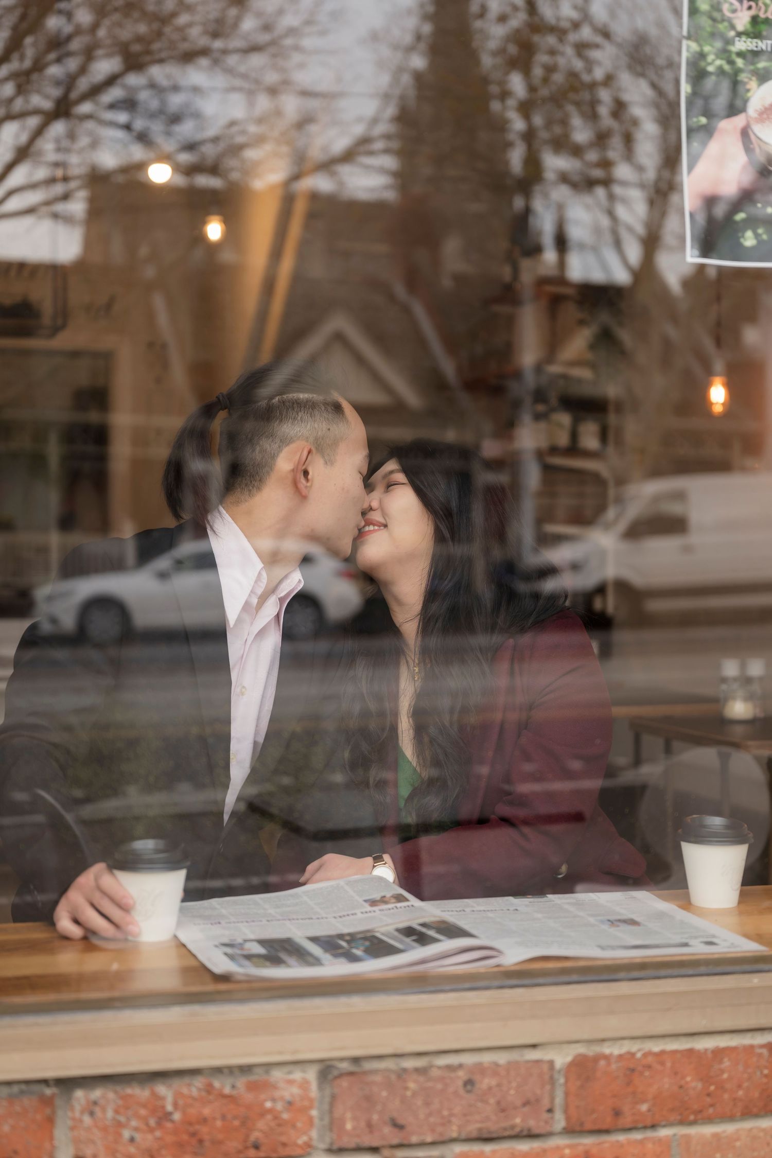 Couple sharing a coffee at a Melbourne café during their engagement photos.