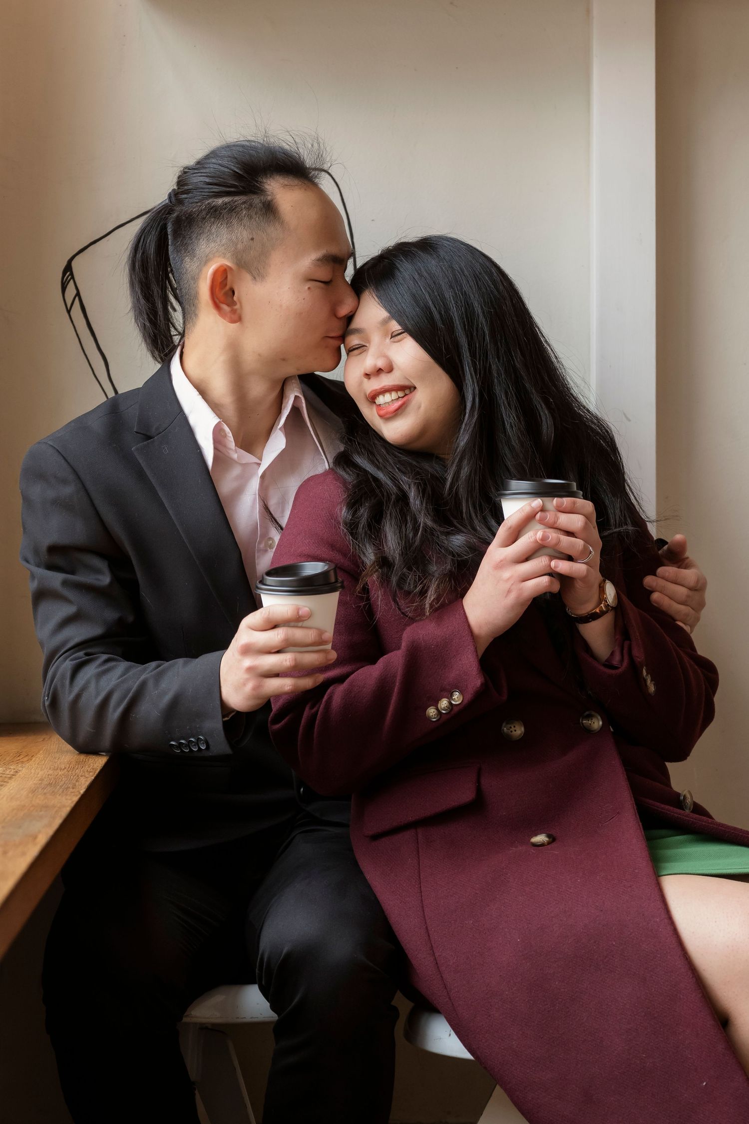 Couple sharing a coffee at a Melbourne café during their engagement photos.