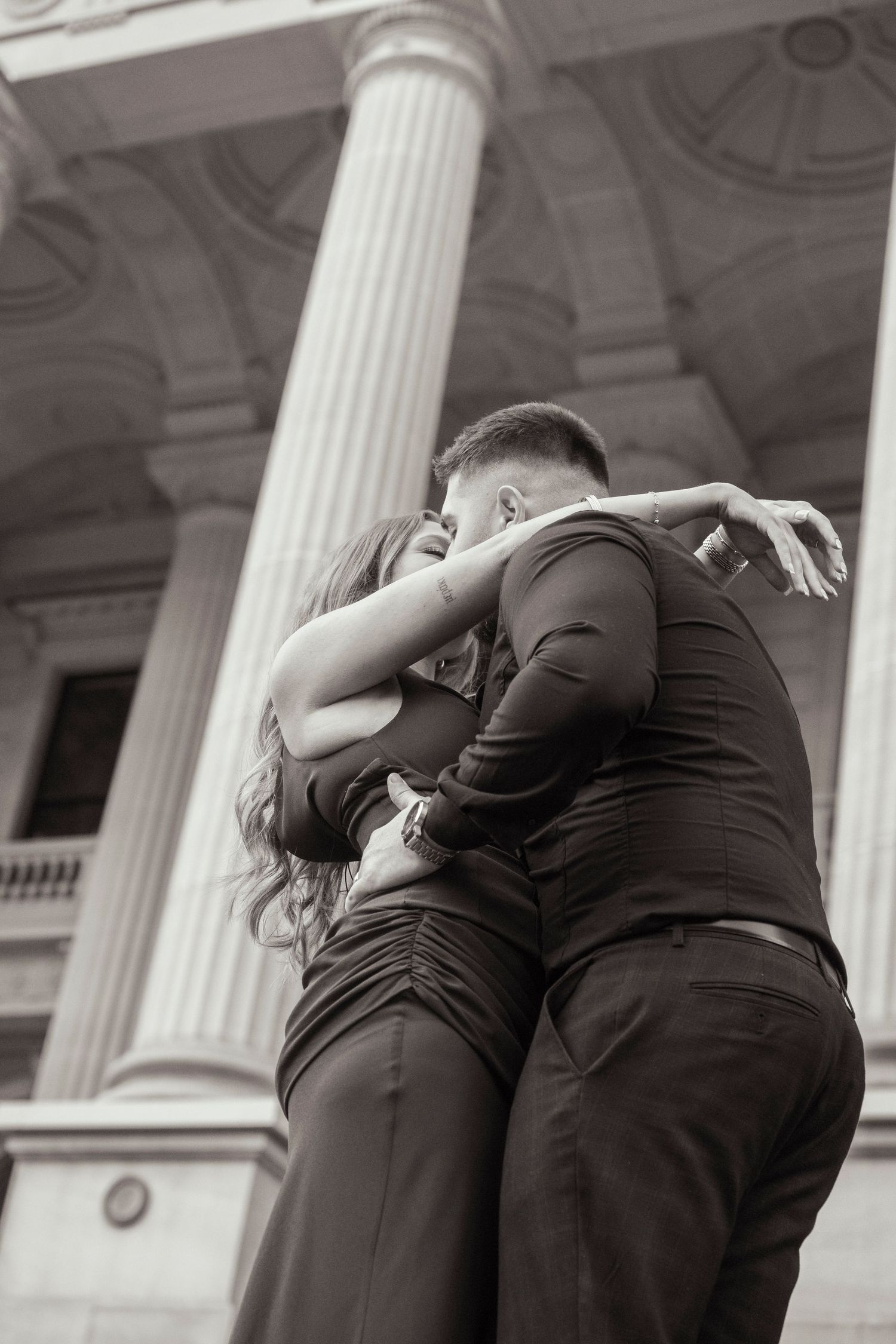 Couple embracing outside Parliament House in Melbourne during their engagement session.