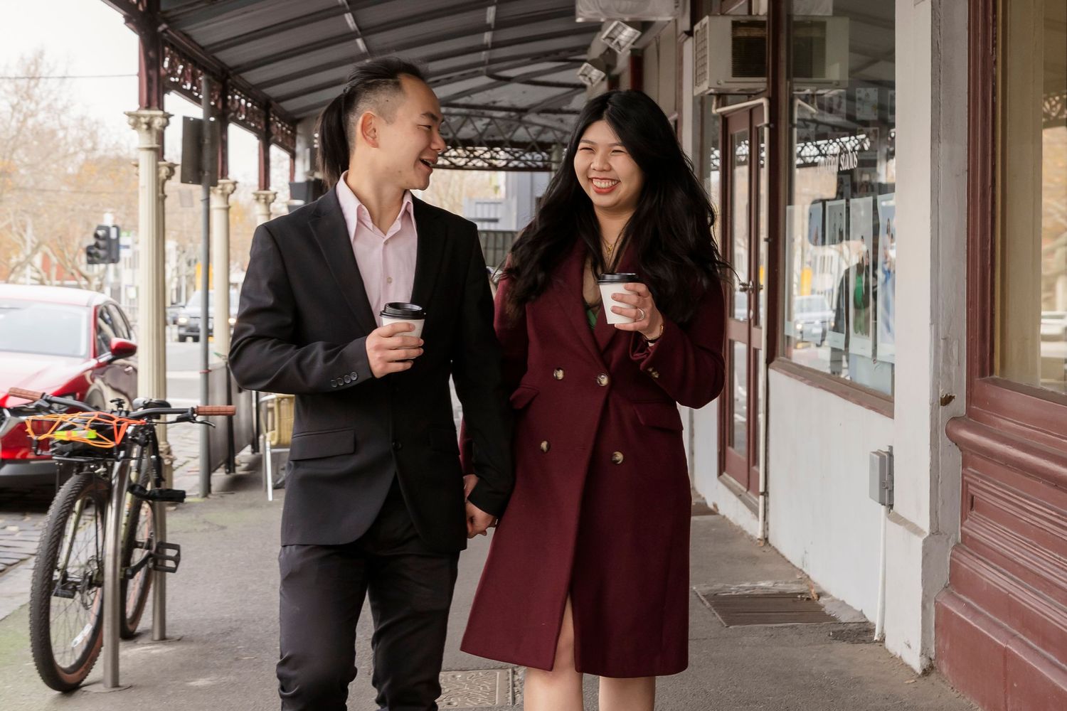 Couple sharing a coffee at a Melbourne café during their engagement photos.