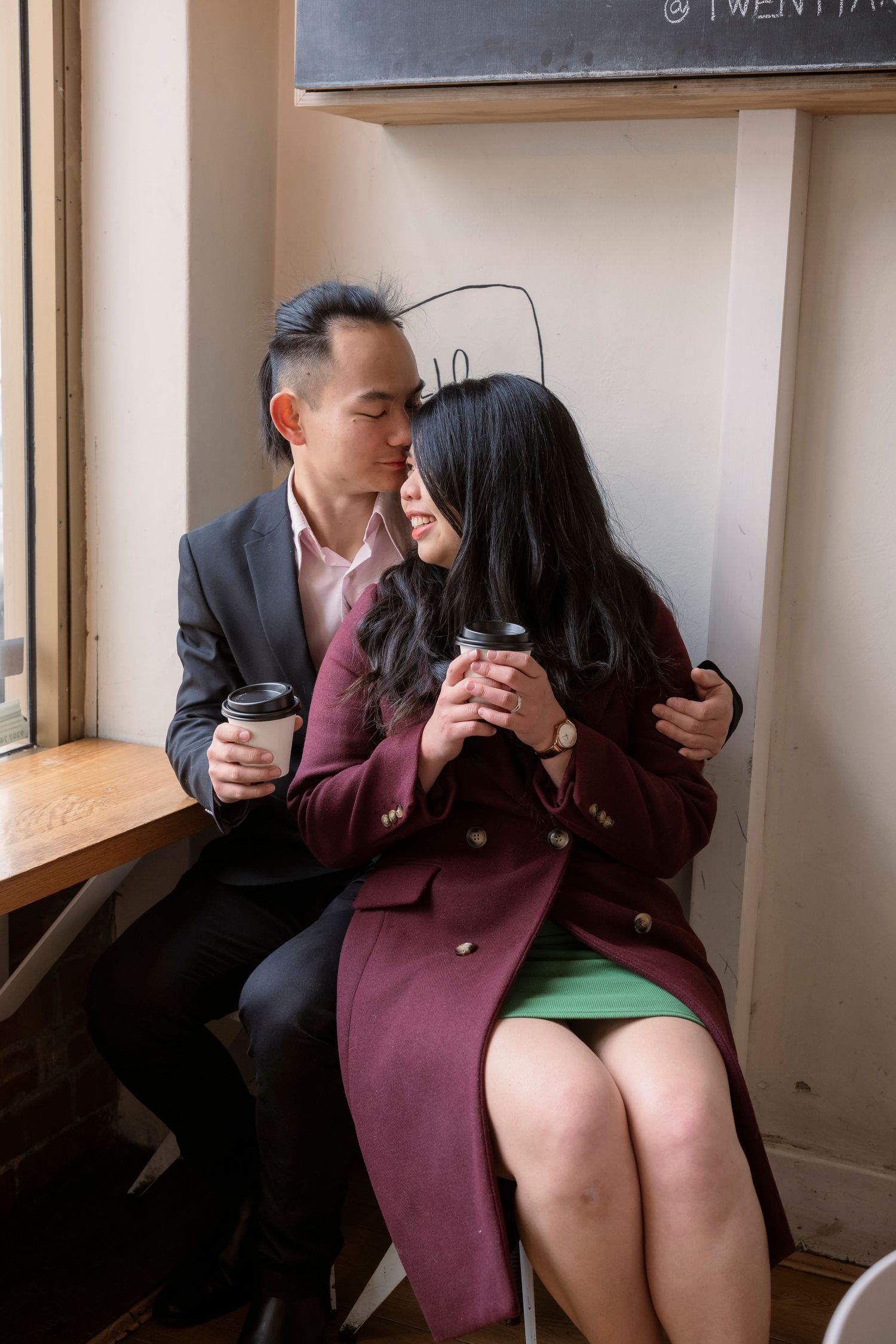 Couple sharing a coffee at a Melbourne café during their engagement photos.
