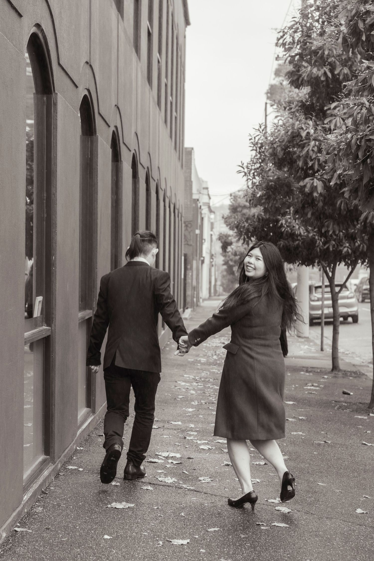 Couple wandering through Melbourne's city streets during their engagement session.