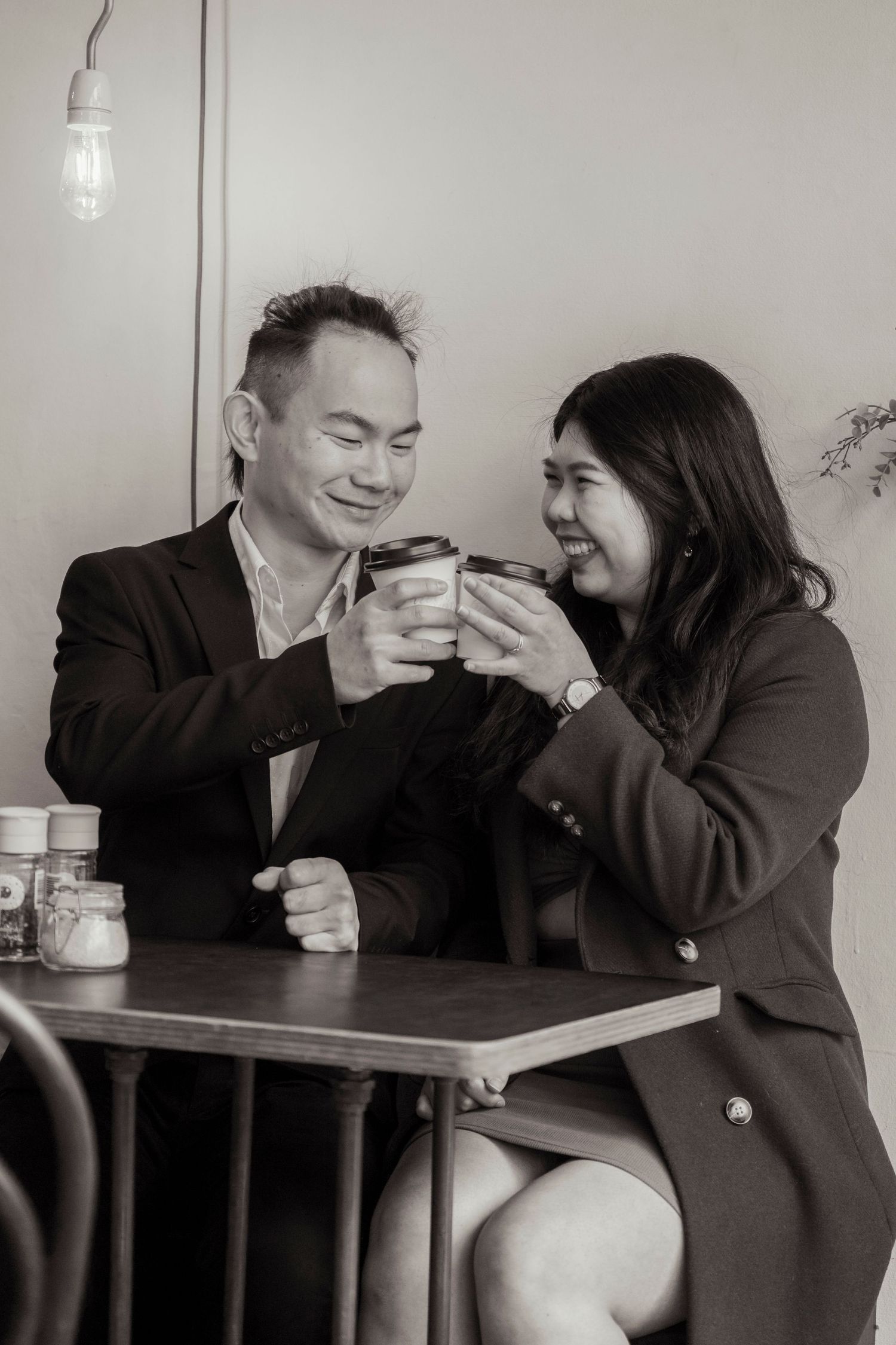 Couple sharing a coffee at a Melbourne café during their engagement photos.