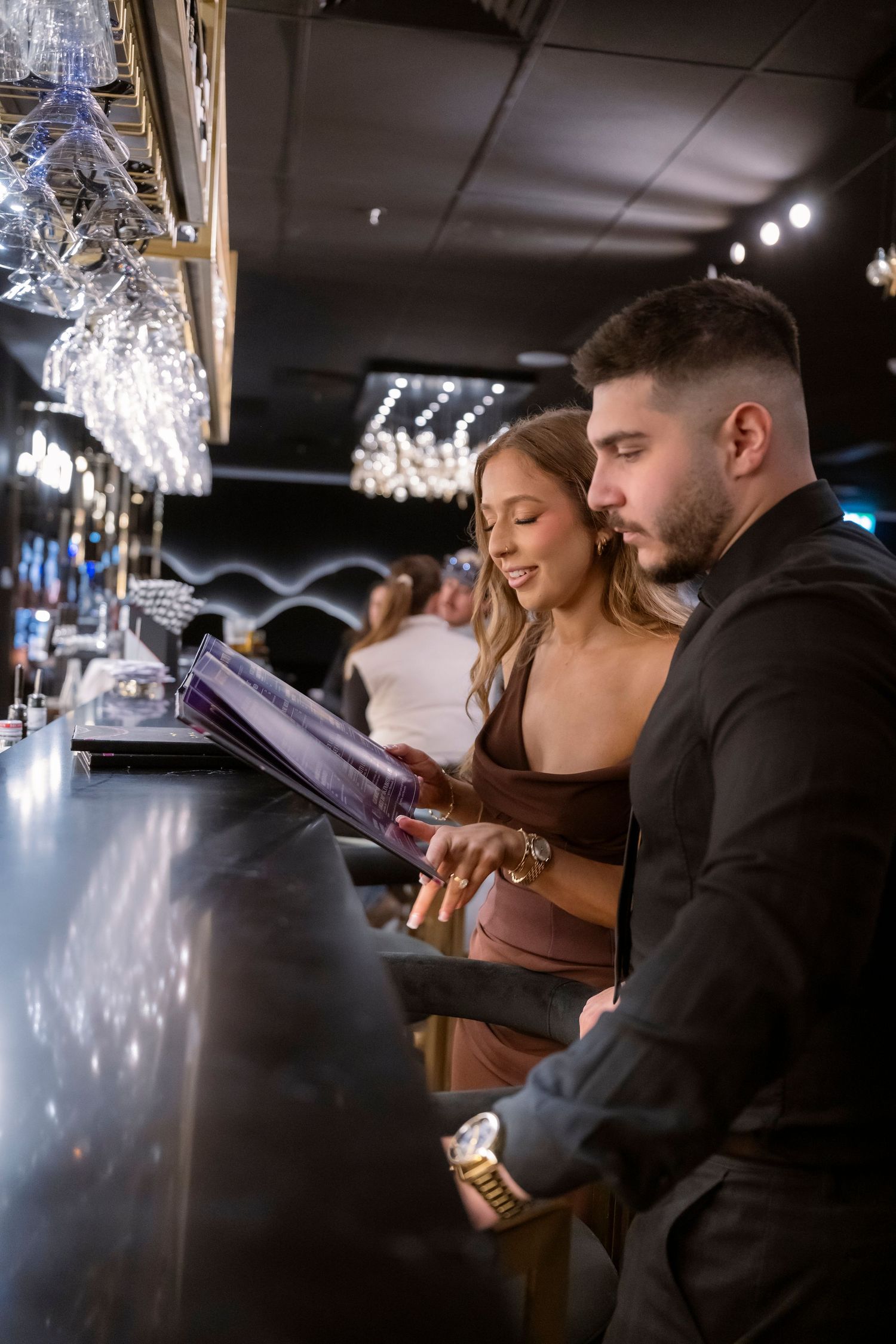 Couple enjoying a drink together at a Melbourne bar during their engagement session.