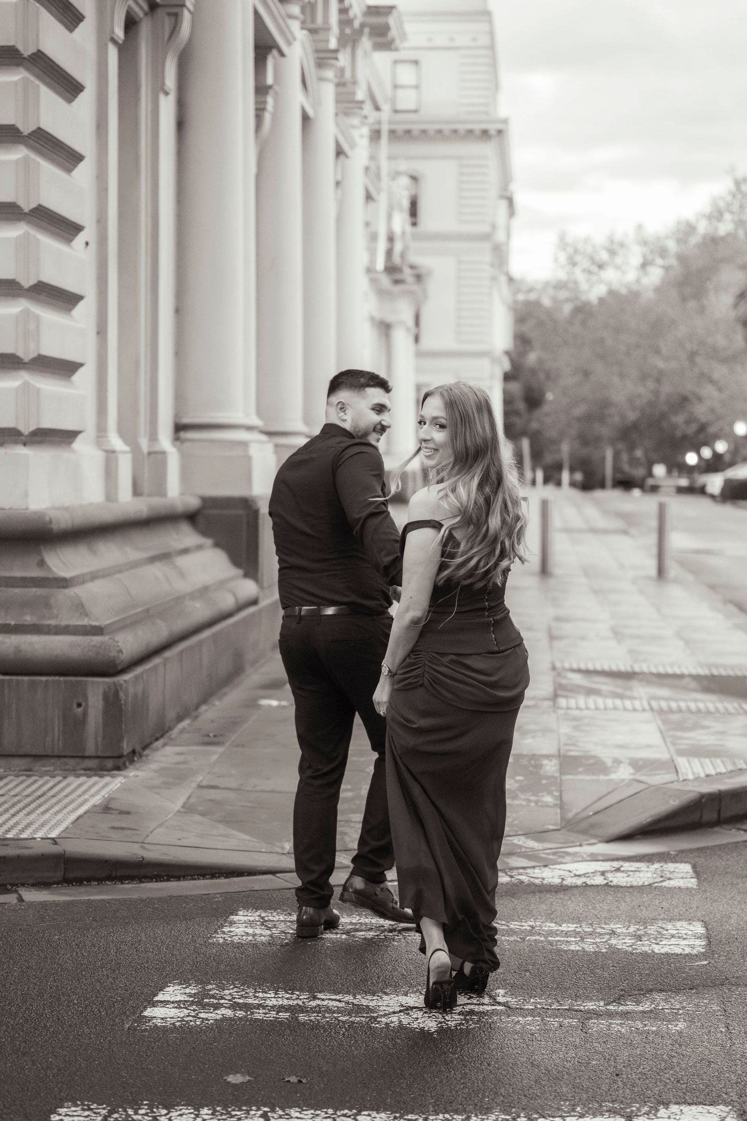 Couple wandering through Melbourne's city streets during their engagement session.