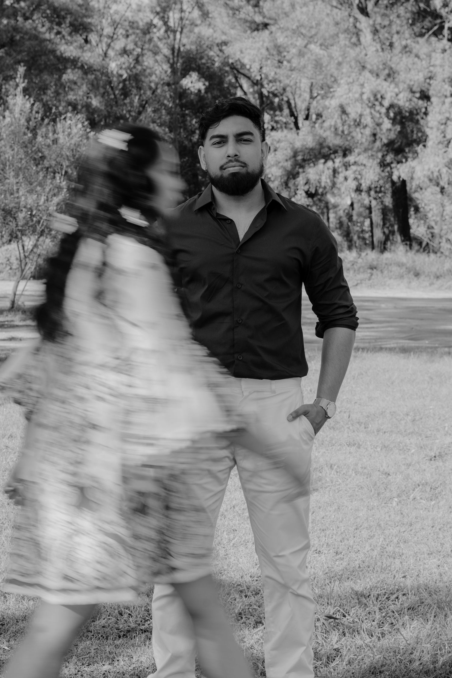 Artistic black and white photo with motion blur of couple in outdoor garden setting.