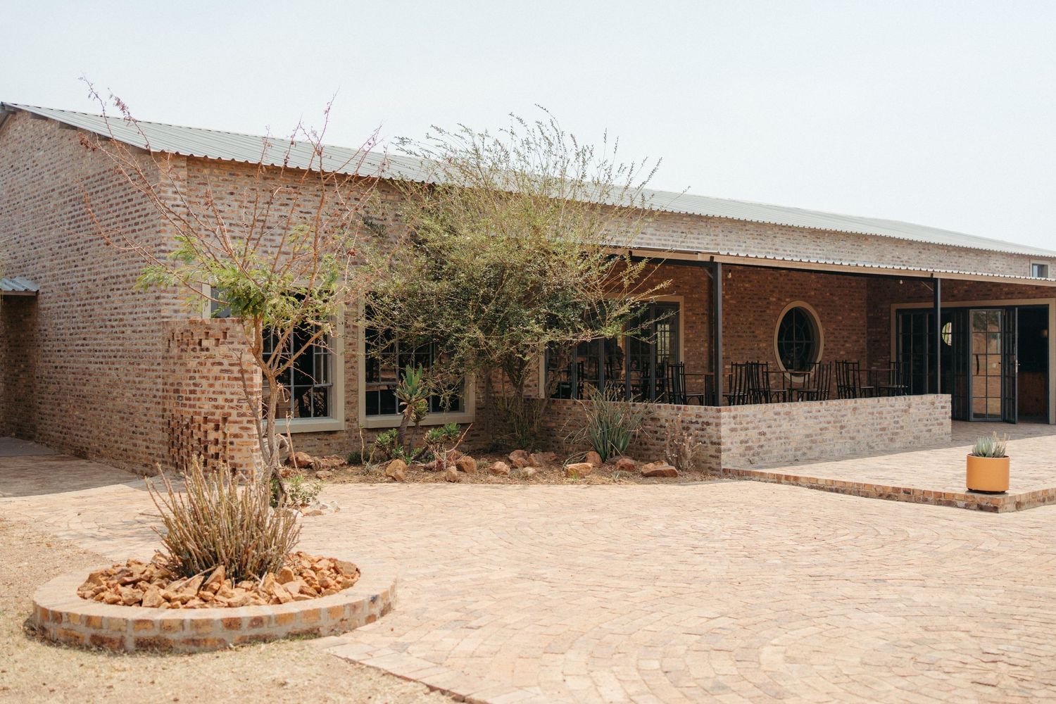 A modern brick building with desert landscaping and a circular window feature.
