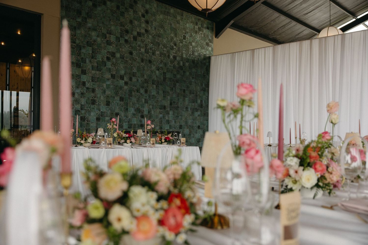 Elegant wedding reception with pink candles, floral centerpieces, and draped white curtains at Tafika Polo Farm.