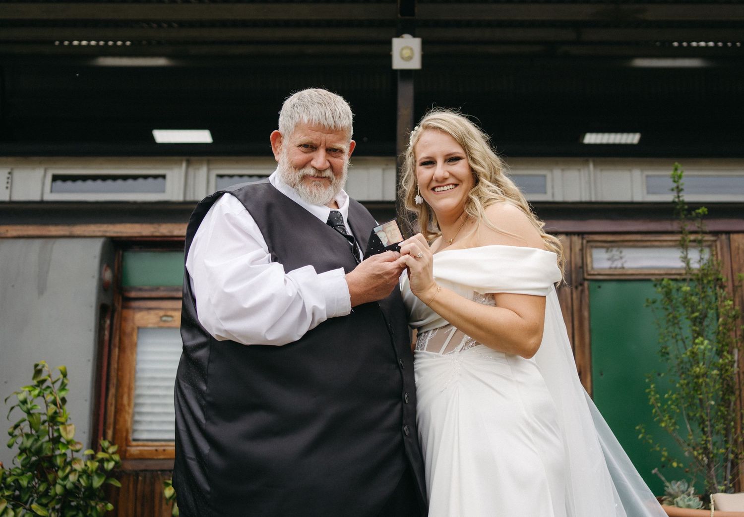 Bride and attendant sharing a special moment outside a rustic venue.