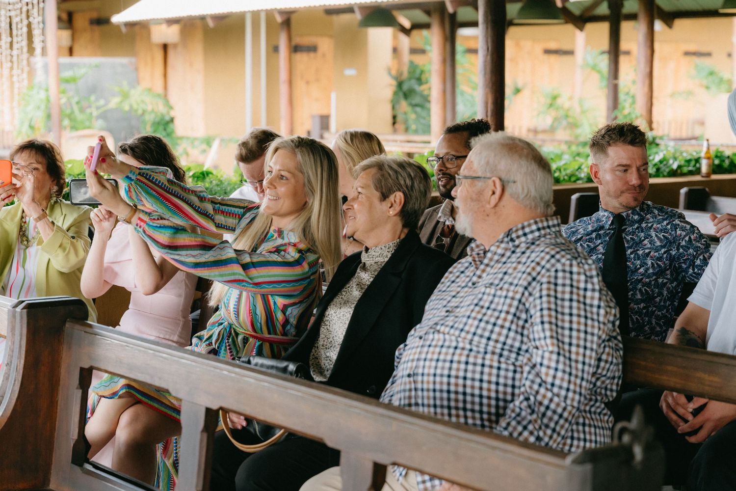 Wedding guests seated at outdoor reception venue watching the celebrations.