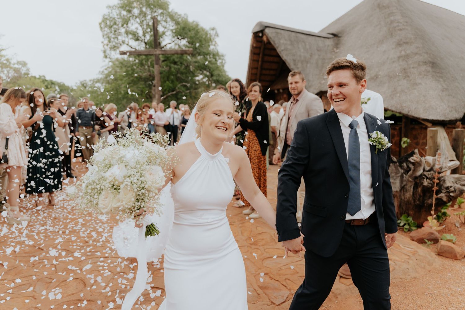 Wedding party celebrates with confetti toss in a joyful outdoor ceremony.