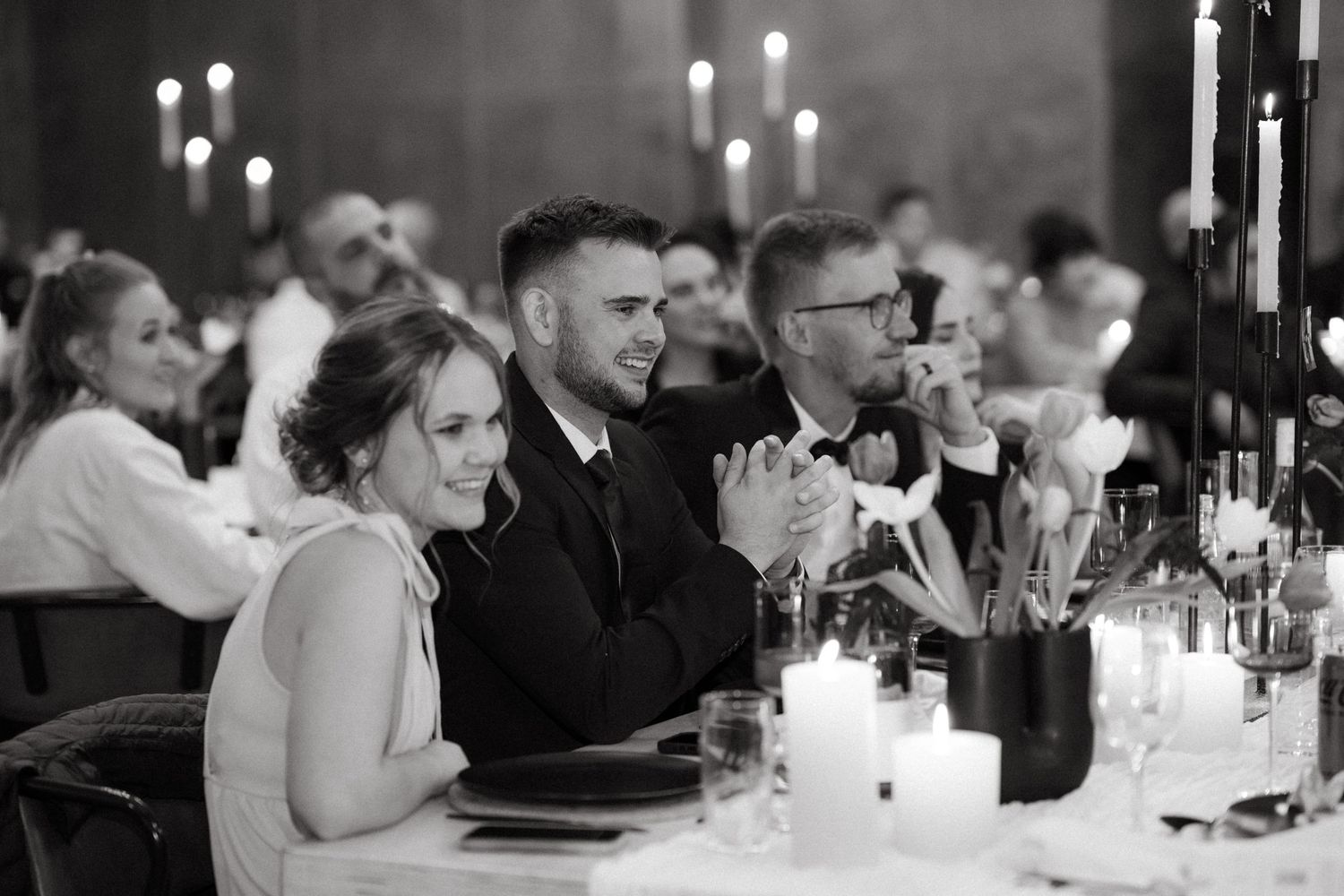 Wedding guests seated at candlelit tables during an elegant evening reception.
