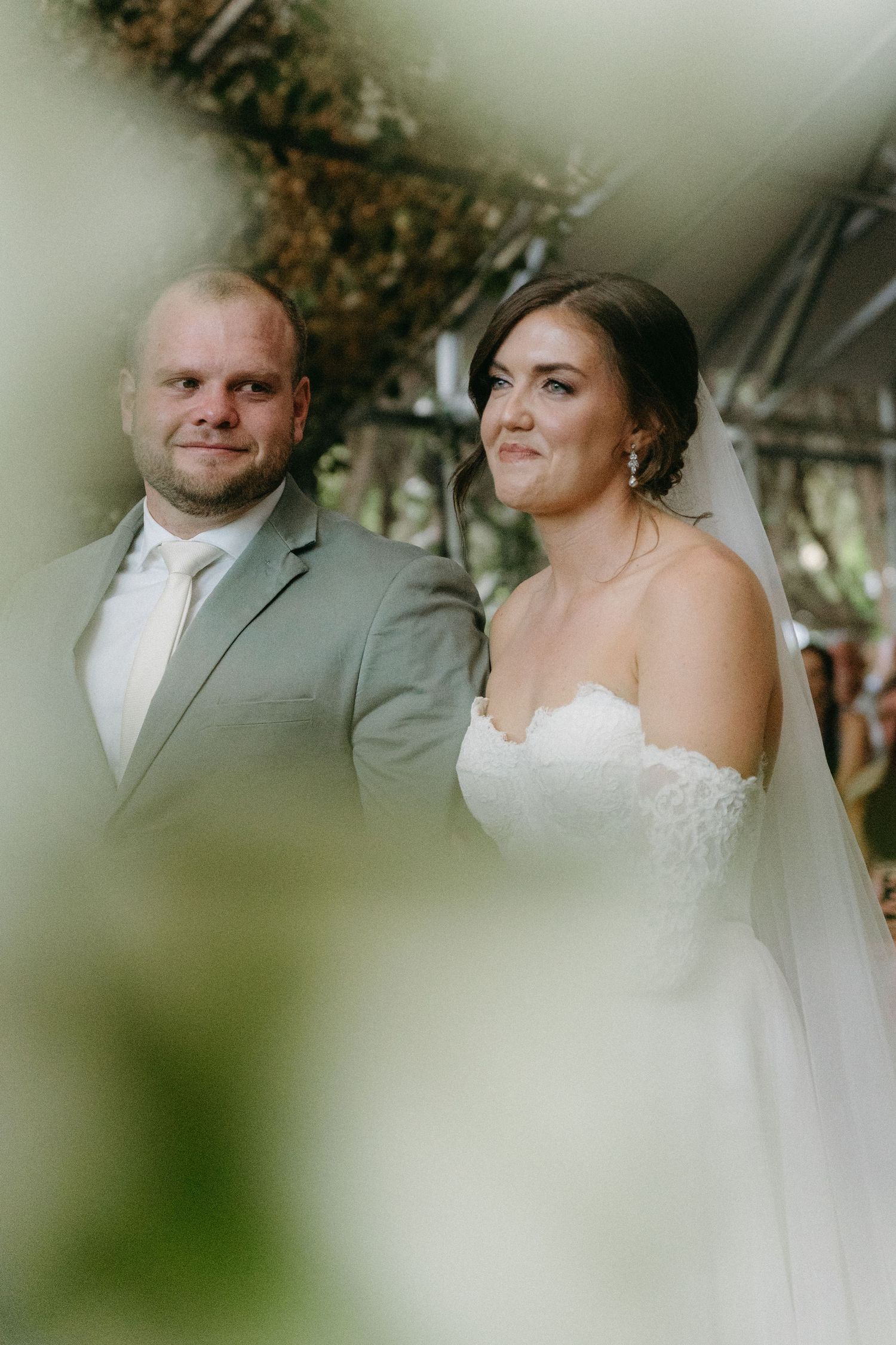 Wedding portrait of couple in gray suit and white dress with natural lighting.
