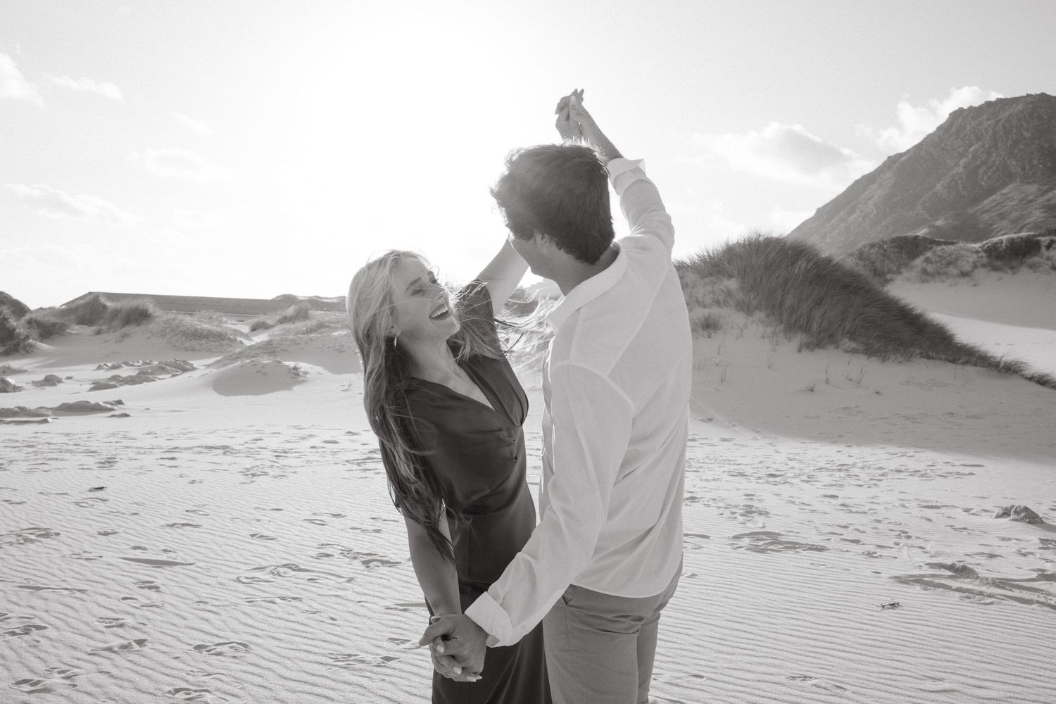 Black and white photo of couple dancing together In Betty''s Bay in romantic outdoor session.