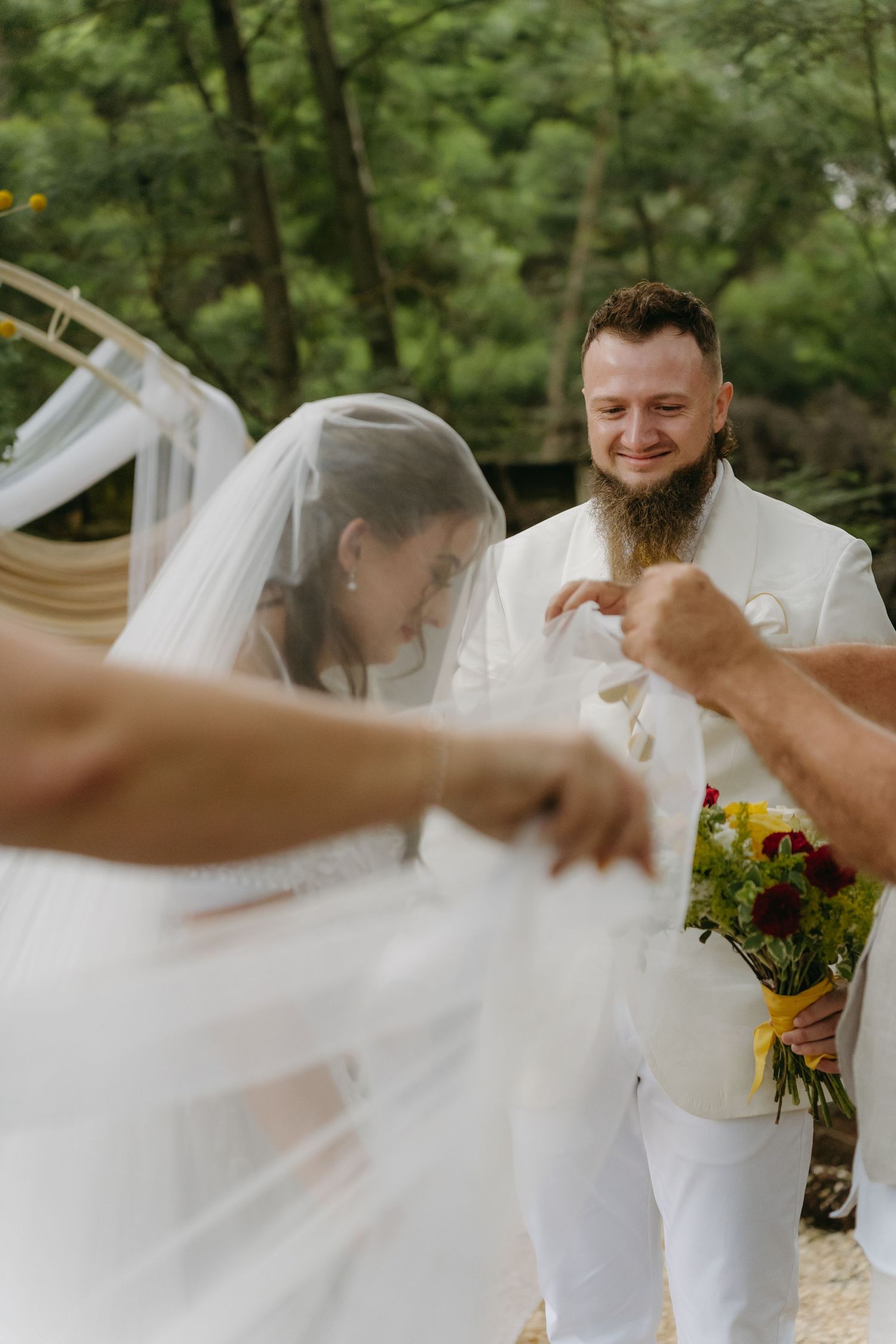 A candid moment during an outdoor woodland wedding ceremony.
