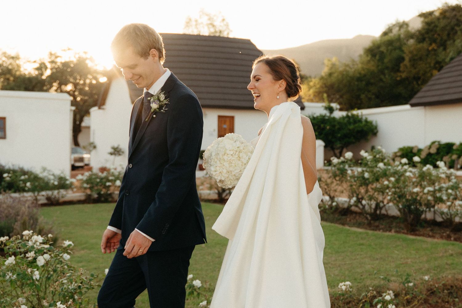 Bride and groom share intimate moments in a garden setting during golden hour wedding photography session.